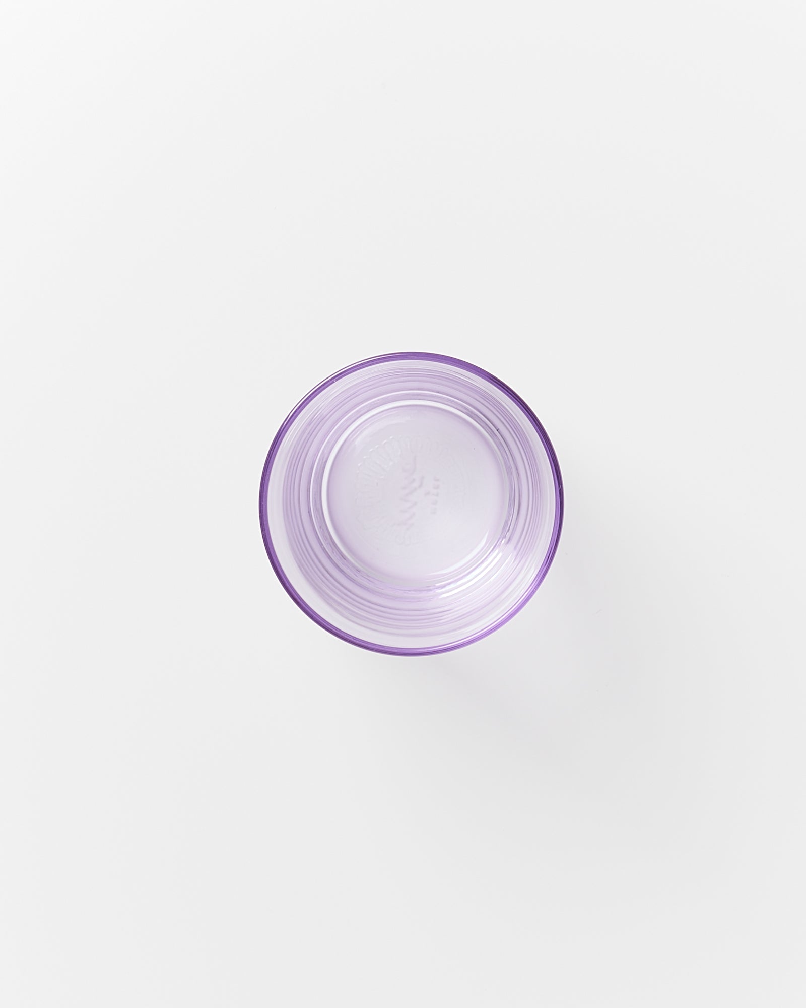 Lila Glas von oben fotografiert auf weißem Hintergrund.