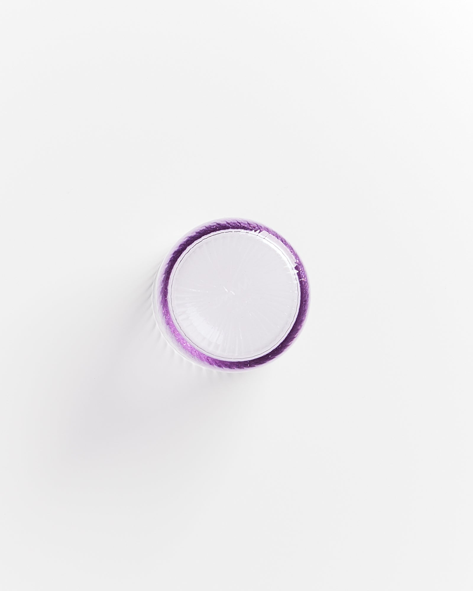 Lila-umrandeter Teller von oben fotografiert auf weißem Hintergrund.