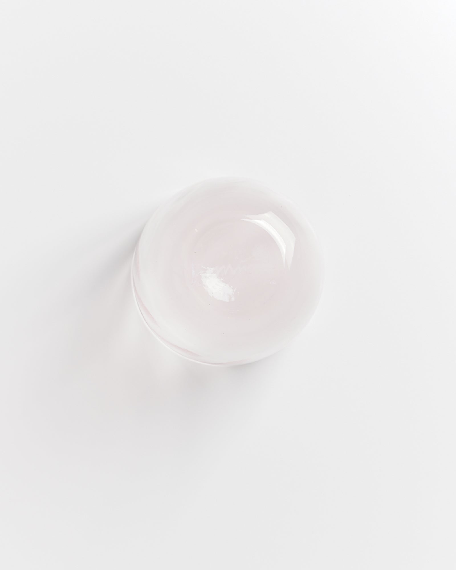 Eine minimalistische transparente Glasschale auf einem weißen Hintergrund.