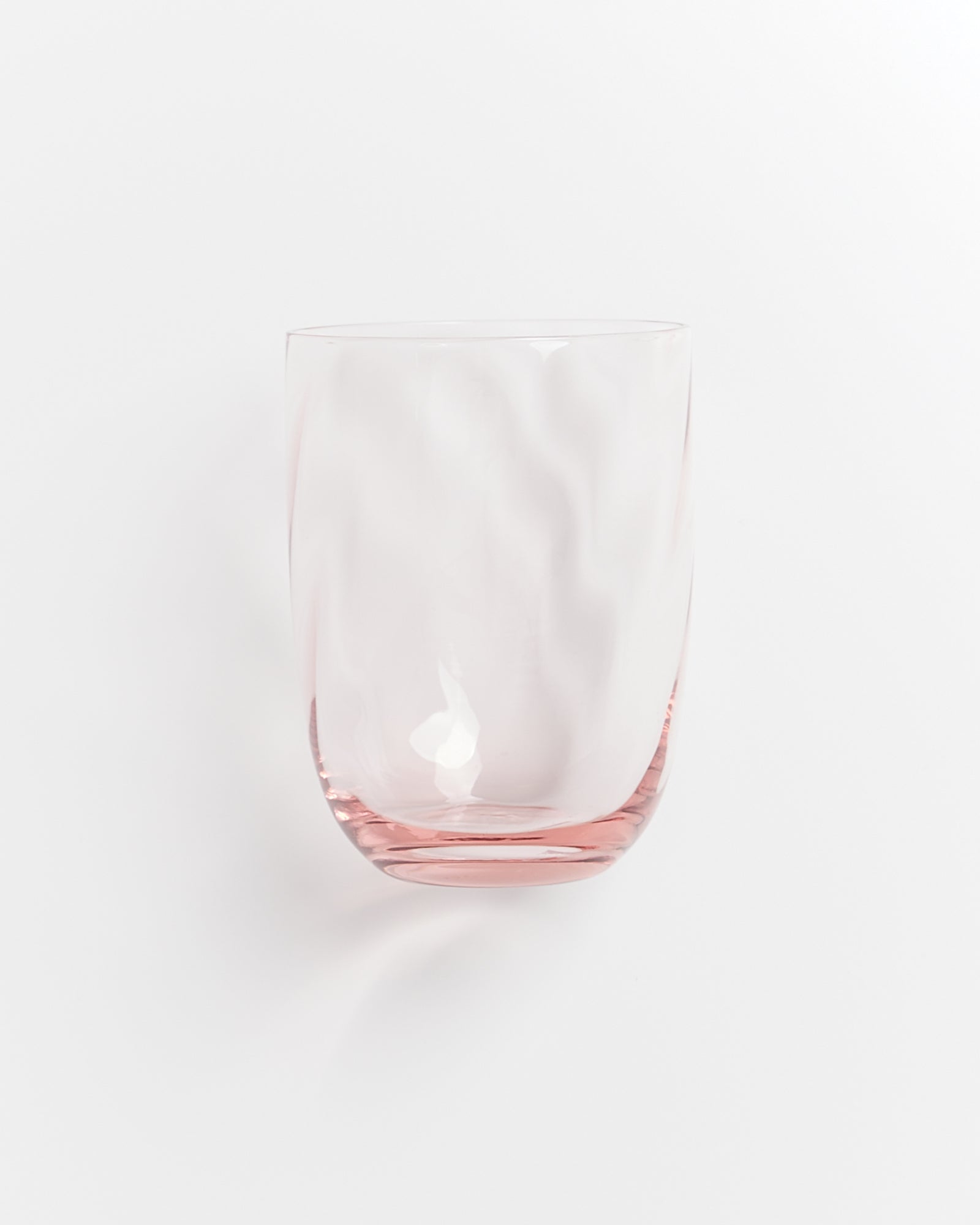 Transparenter, rosa getönter Trinkbecher vor weißem Hintergrund.