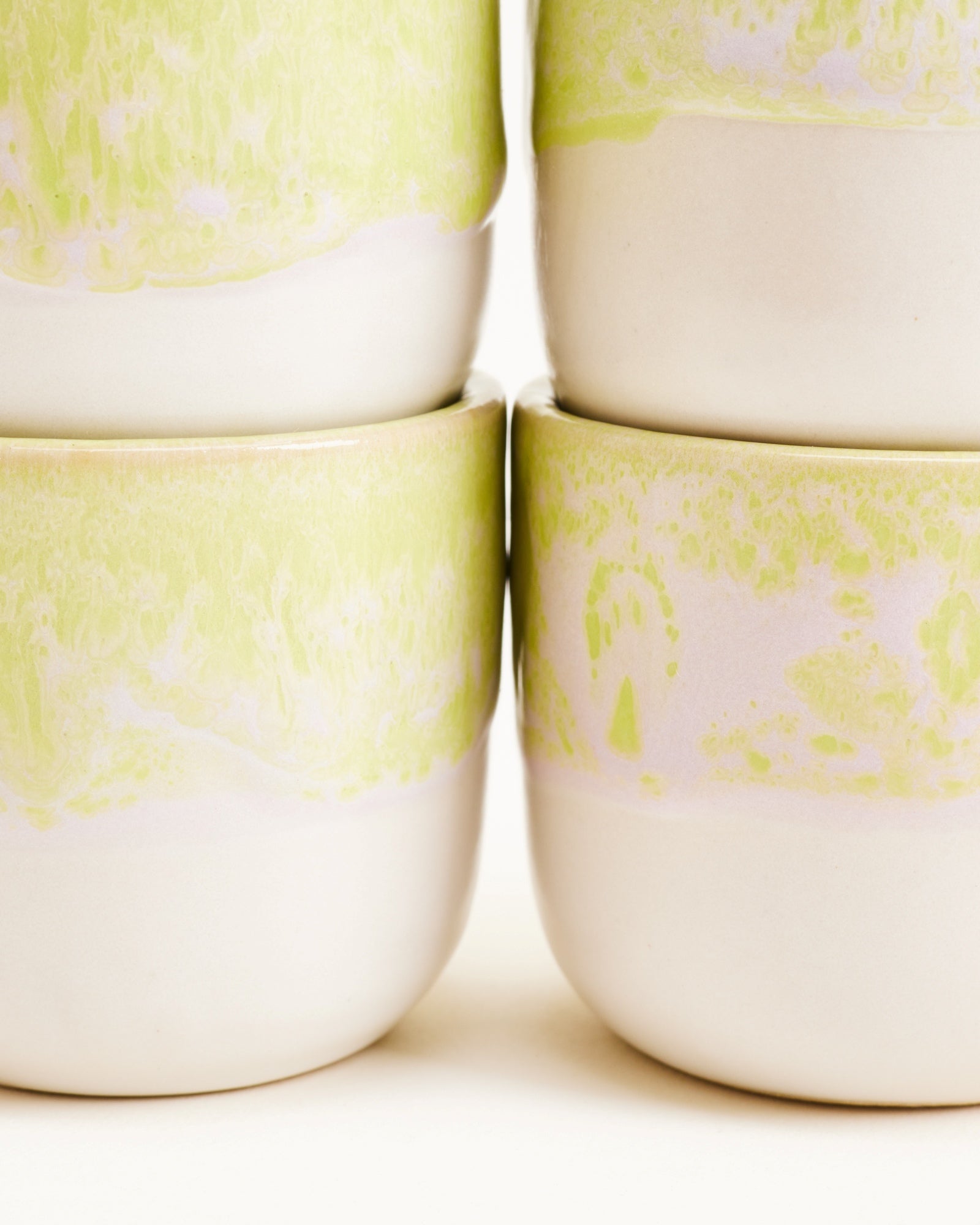 Nahaufnahme von vier gestapelten Keramikschalen mit hellgrünem und weißem Muster.