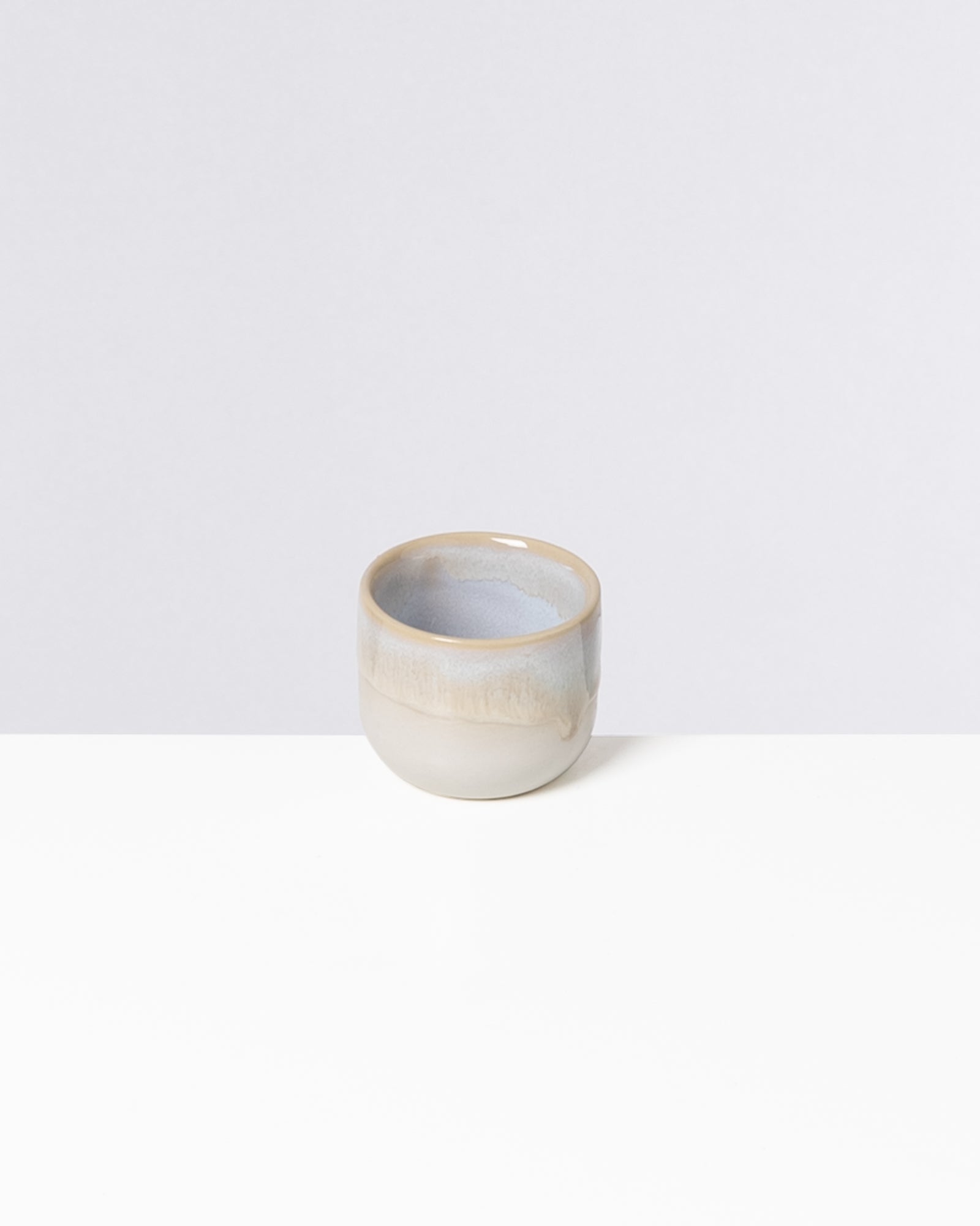 Kleine graue Keramikschale auf einem weißen Hintergrund.