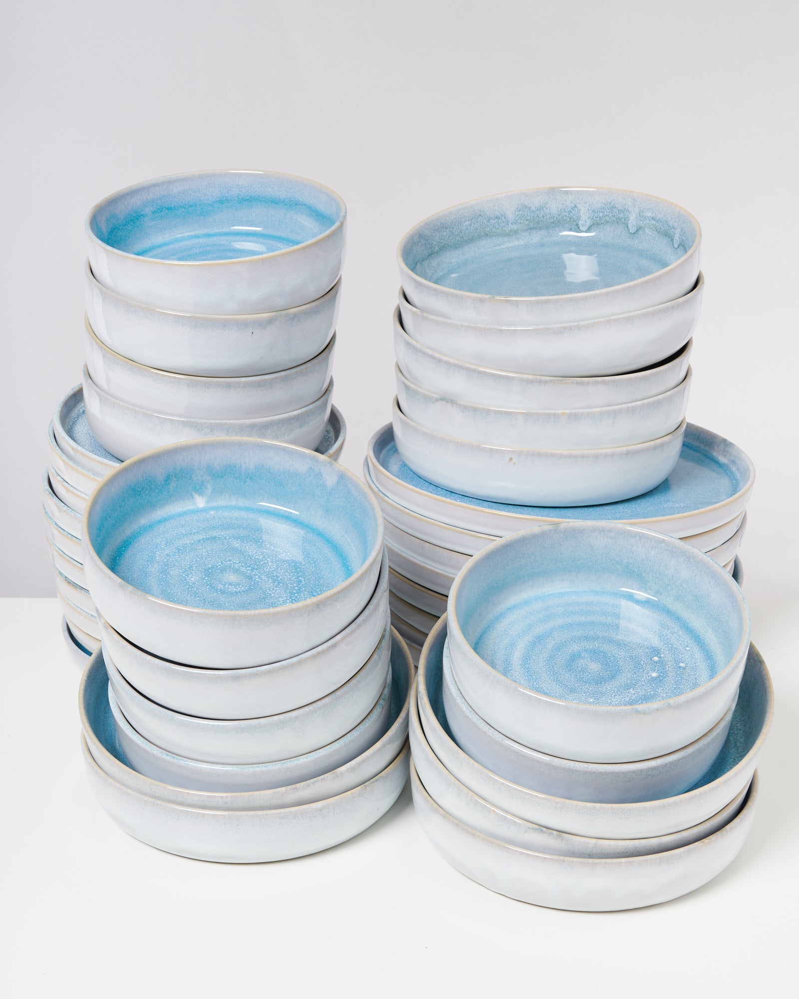 Gestapelte blaue und weiße Keramikteller mit glänzender Oberfläche auf einem Tisch.
