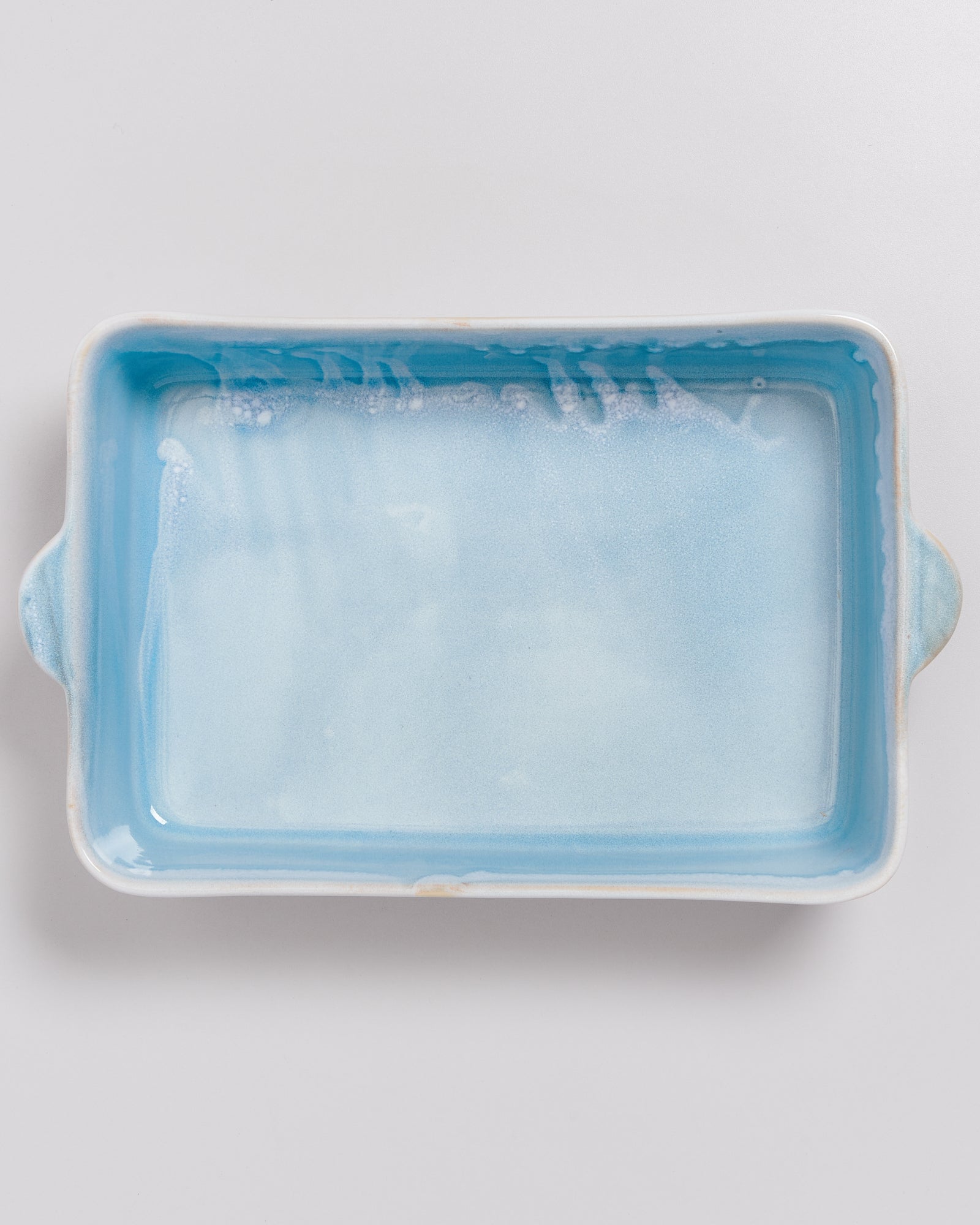 Rechteckige, hellblaue Keramikauflaufform mit zwei Griffen, von oben fotografiert.
