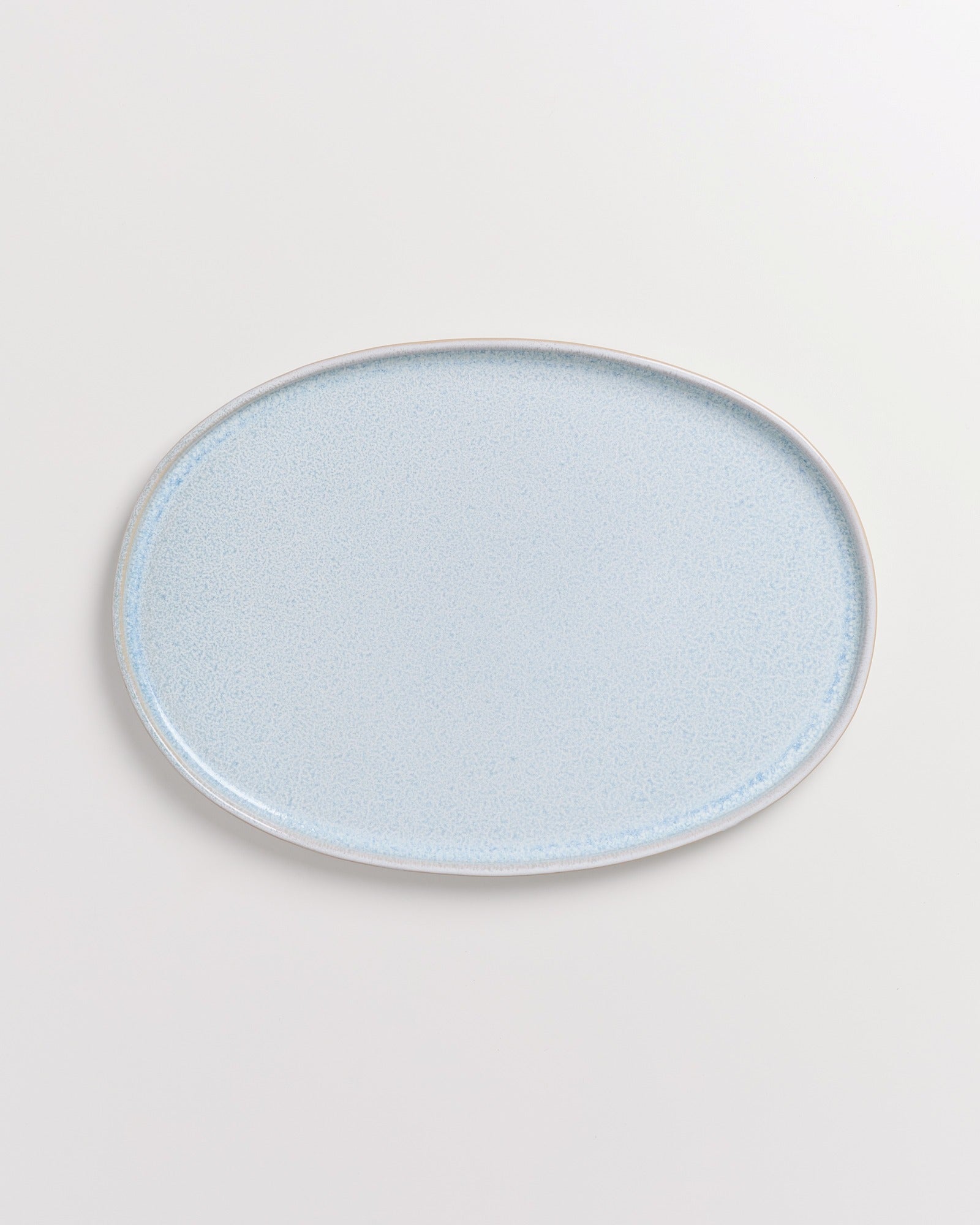 Ein ovaler, hellblauer Teller auf weißem Hintergrund.