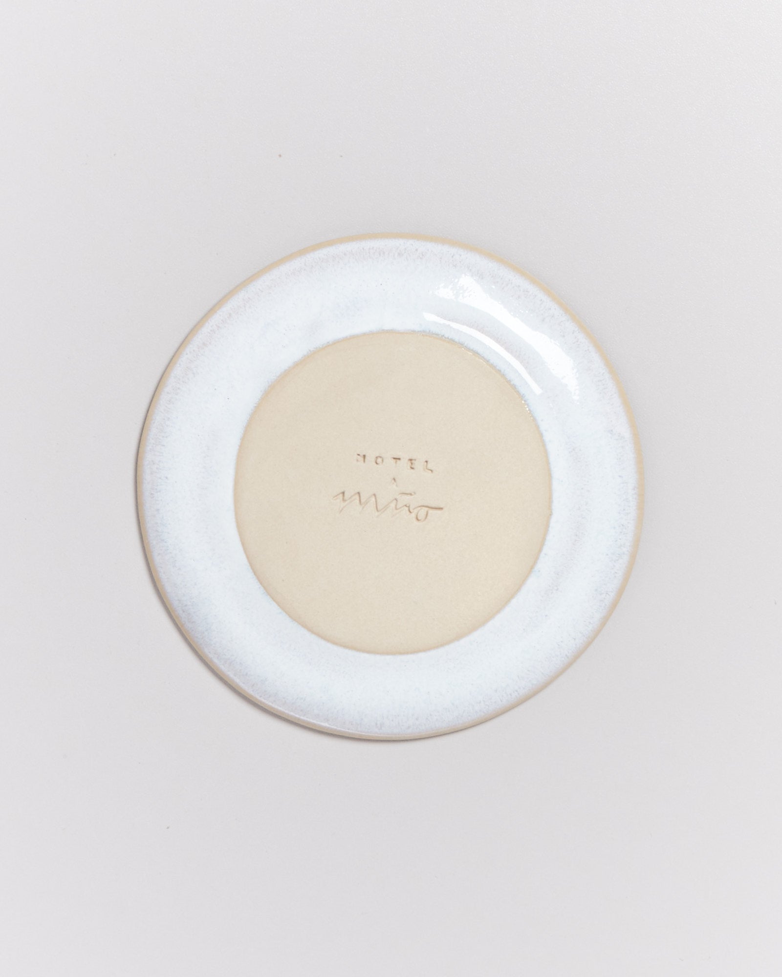 Ein Teller mit hellen und dunklen Rändern, beschriftet mit "HOTEL".