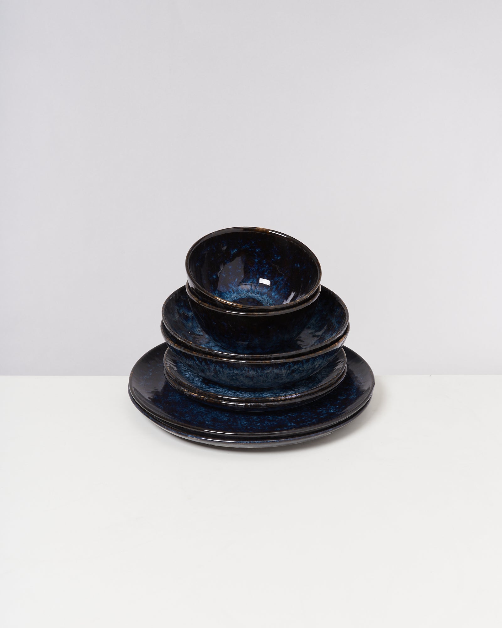 Ein Stapel aus blau gemusterten Schalen und Tellern steht auf einer weißen Fläche.