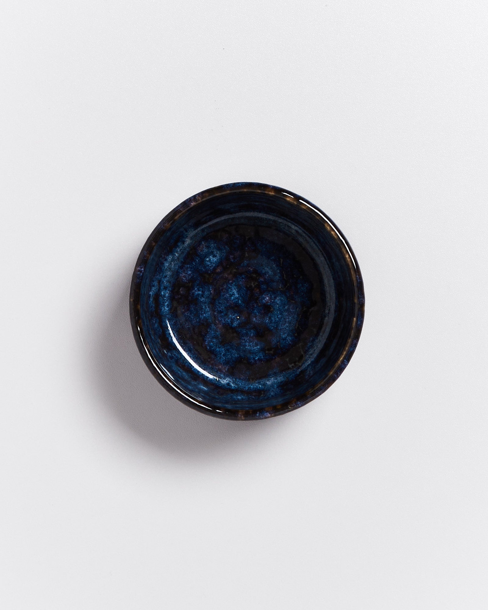 Dunkelblaue Keramikschale auf weißem Hintergrund.