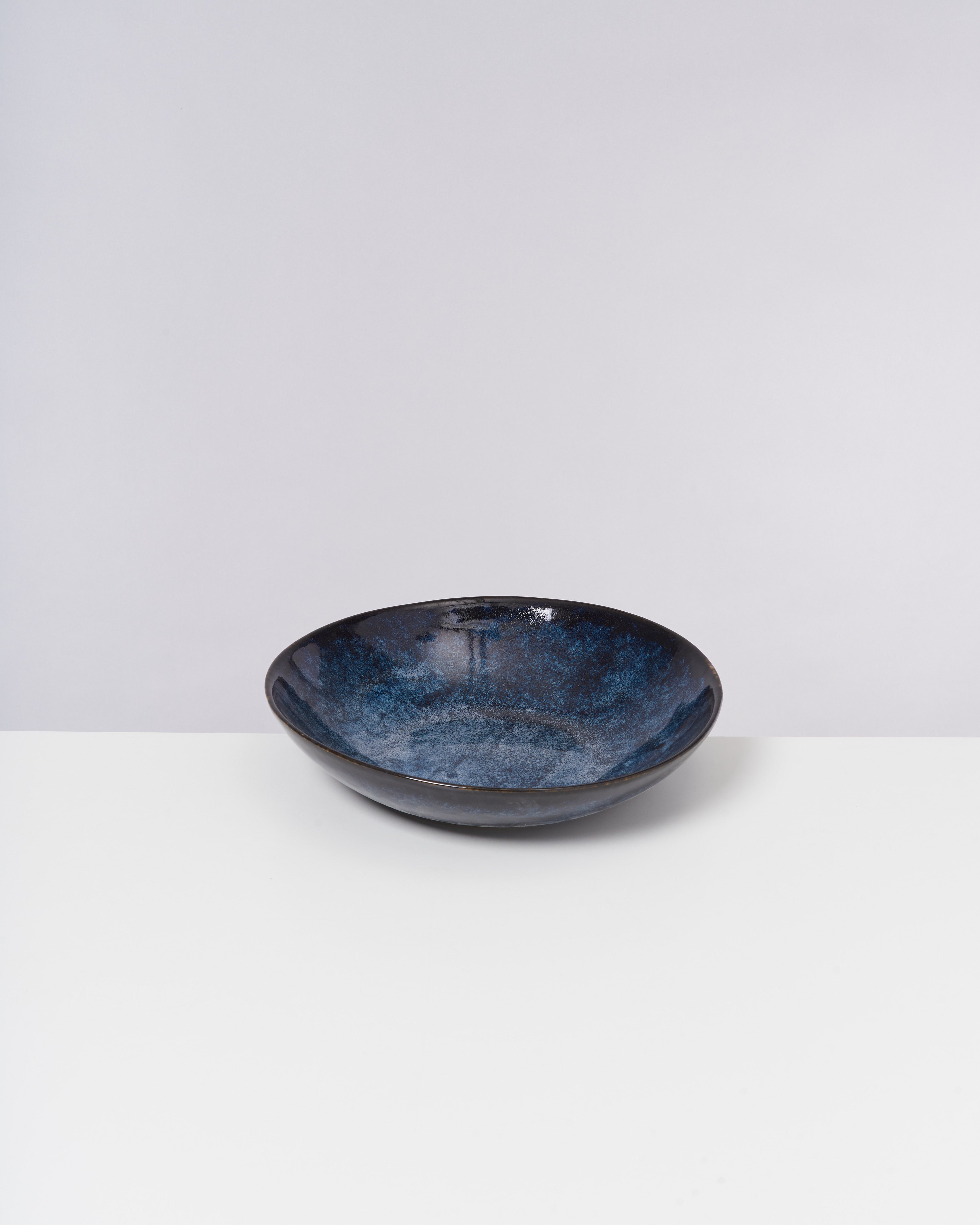 Blau-schwarze Keramikschale auf weißem Hintergrund.