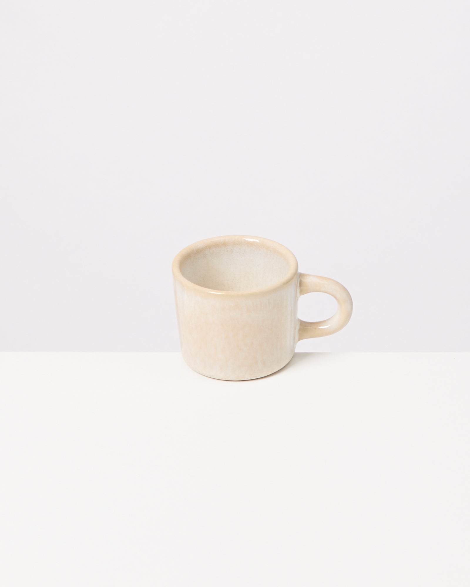 Beige Tasse auf einem weißen Hintergrund.
