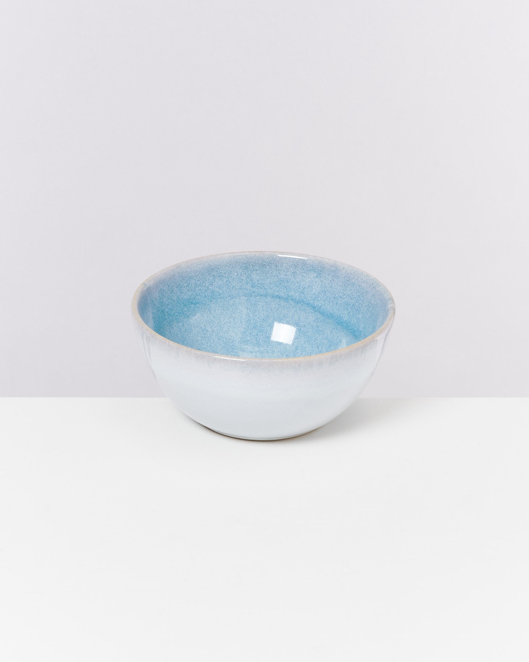 Keramikschüssel mit blauem Inneren auf weißem Hintergrund.