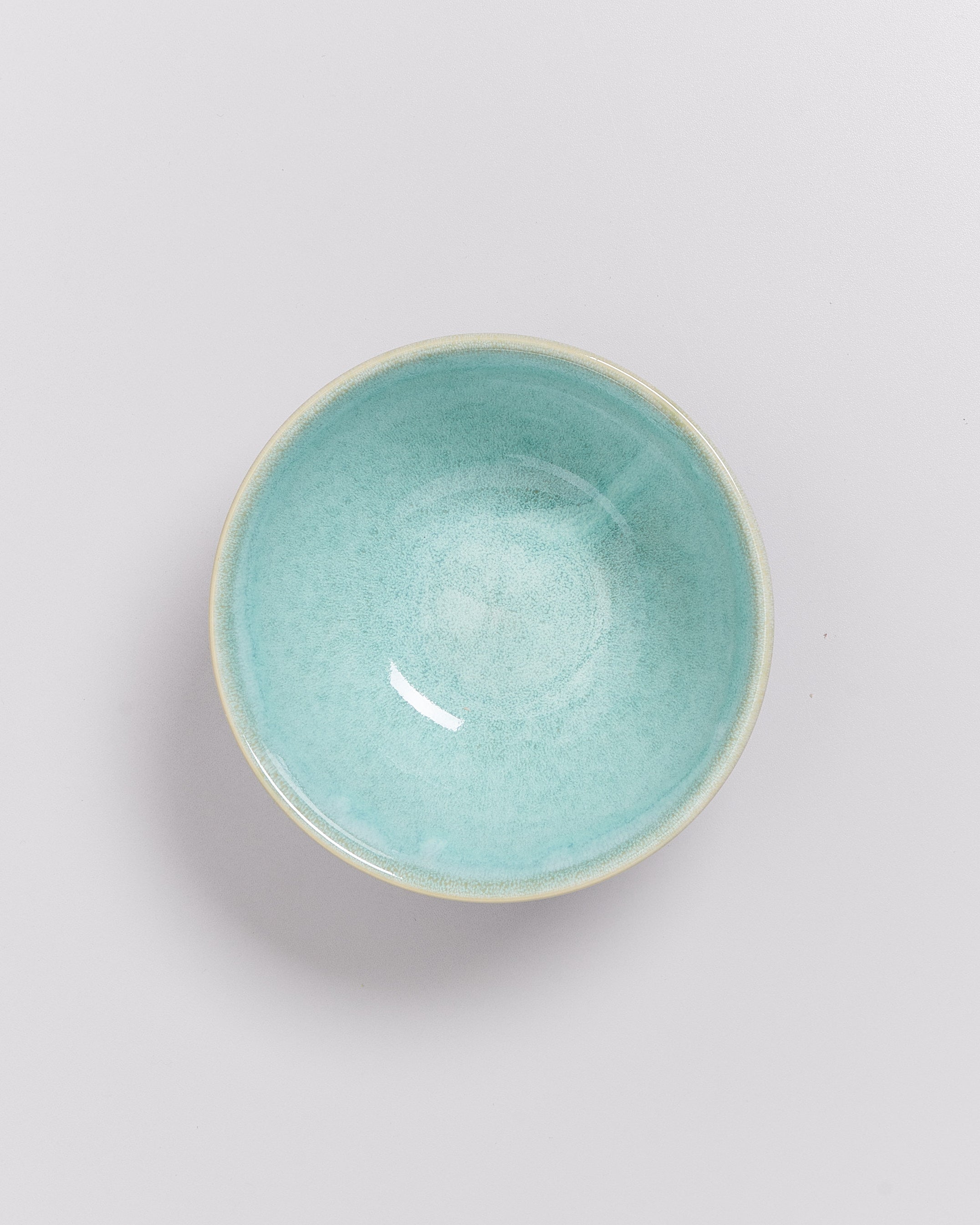 Türkise Keramikschale auf weißem Hintergrund fotografiert.