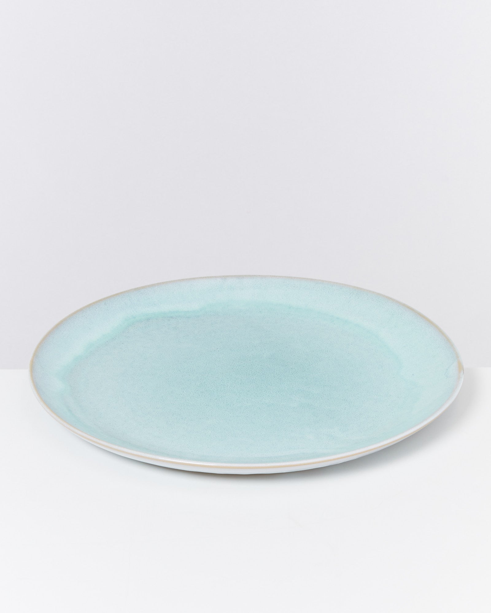 Blaue, runde Keramikplatte auf weißem Hintergrund.