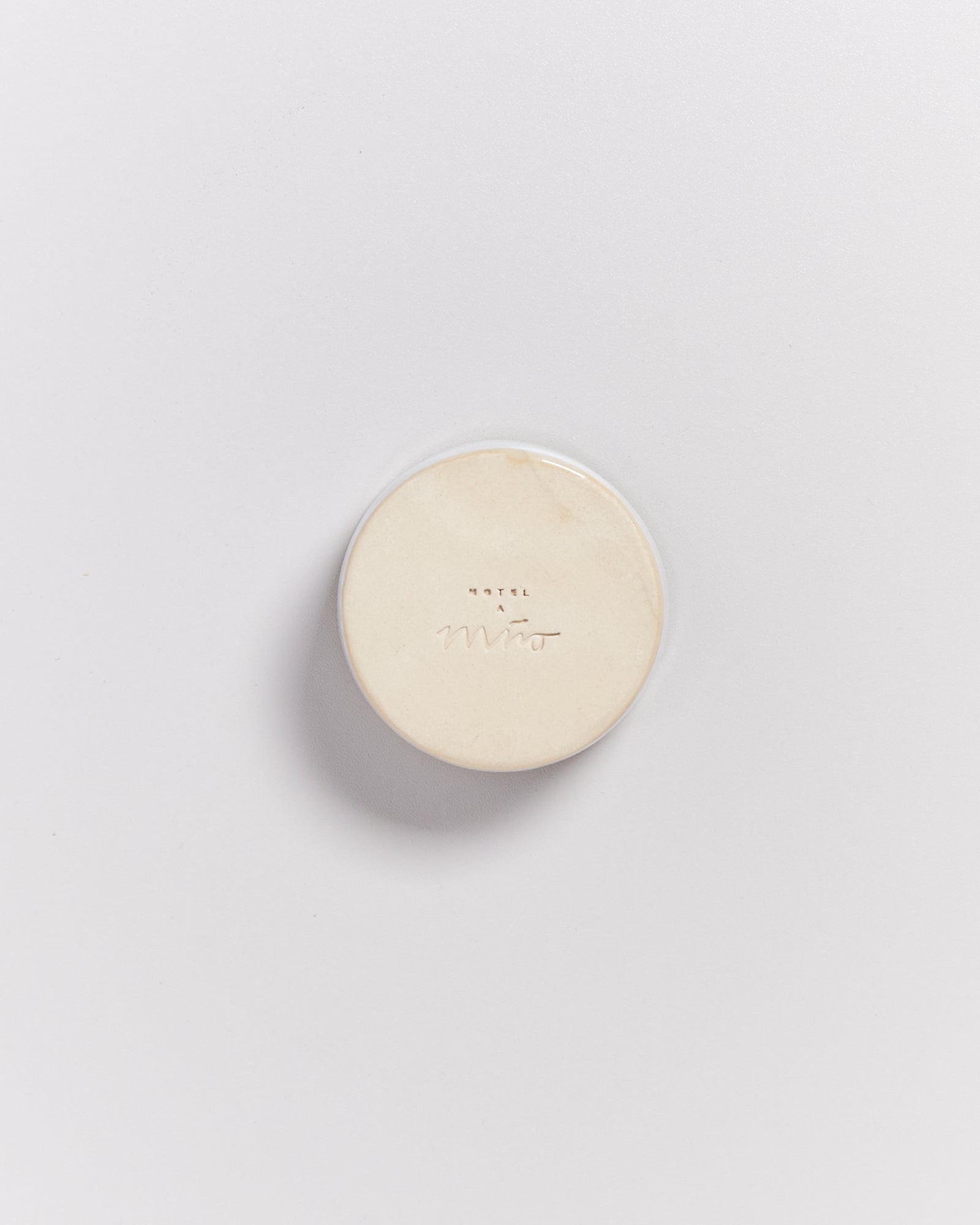 Runde Seife mit geprägtem Logo "Hotel Miro" auf weißem Hintergrund.