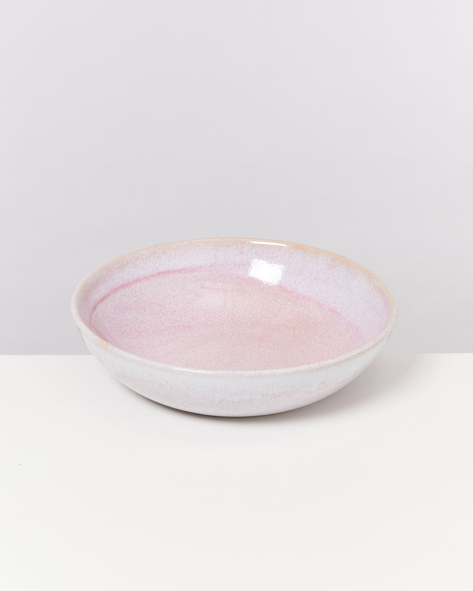 Rosa Schüssel auf weißem Hintergrund, leicht glänzende Oberfläche.
