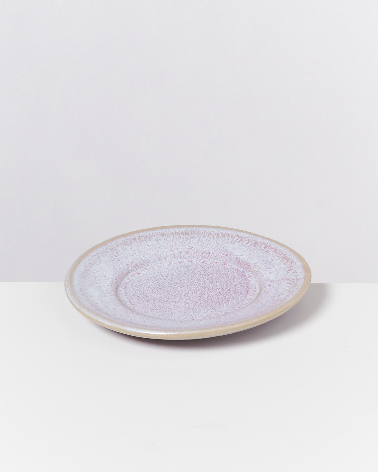 Flacher, pastellfarbener Teller mit leicht strukturierter Oberfläche auf weißem Hintergrund.