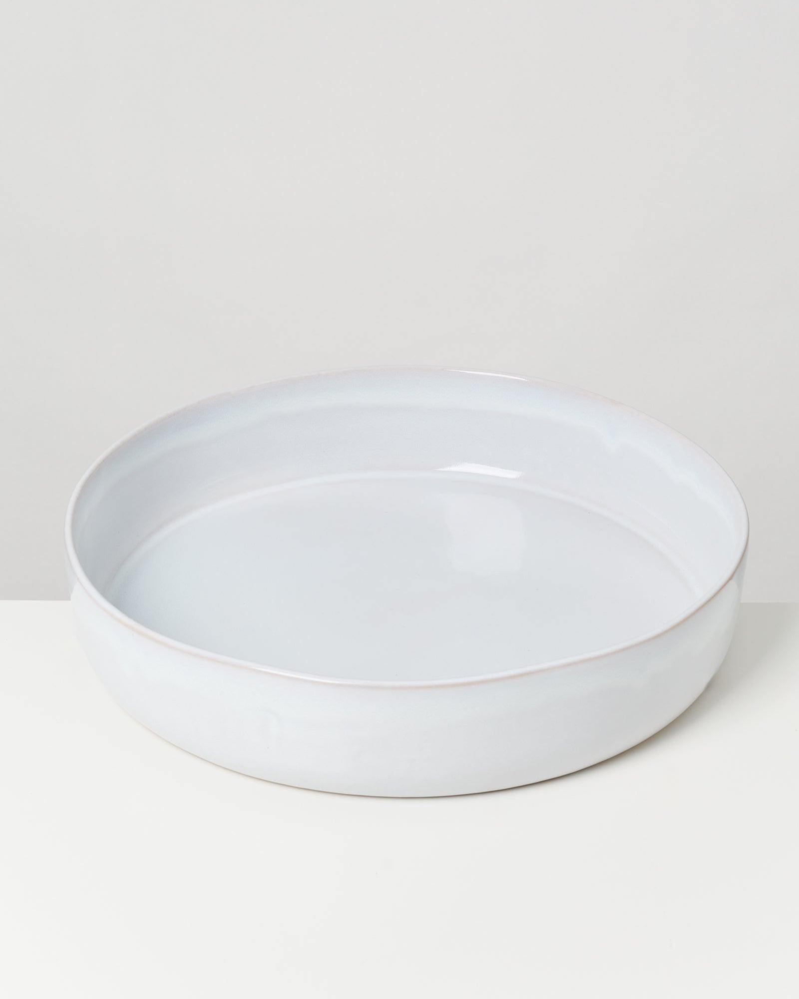 Weiße, runde Keramikschale auf einem weißen Hintergrund.