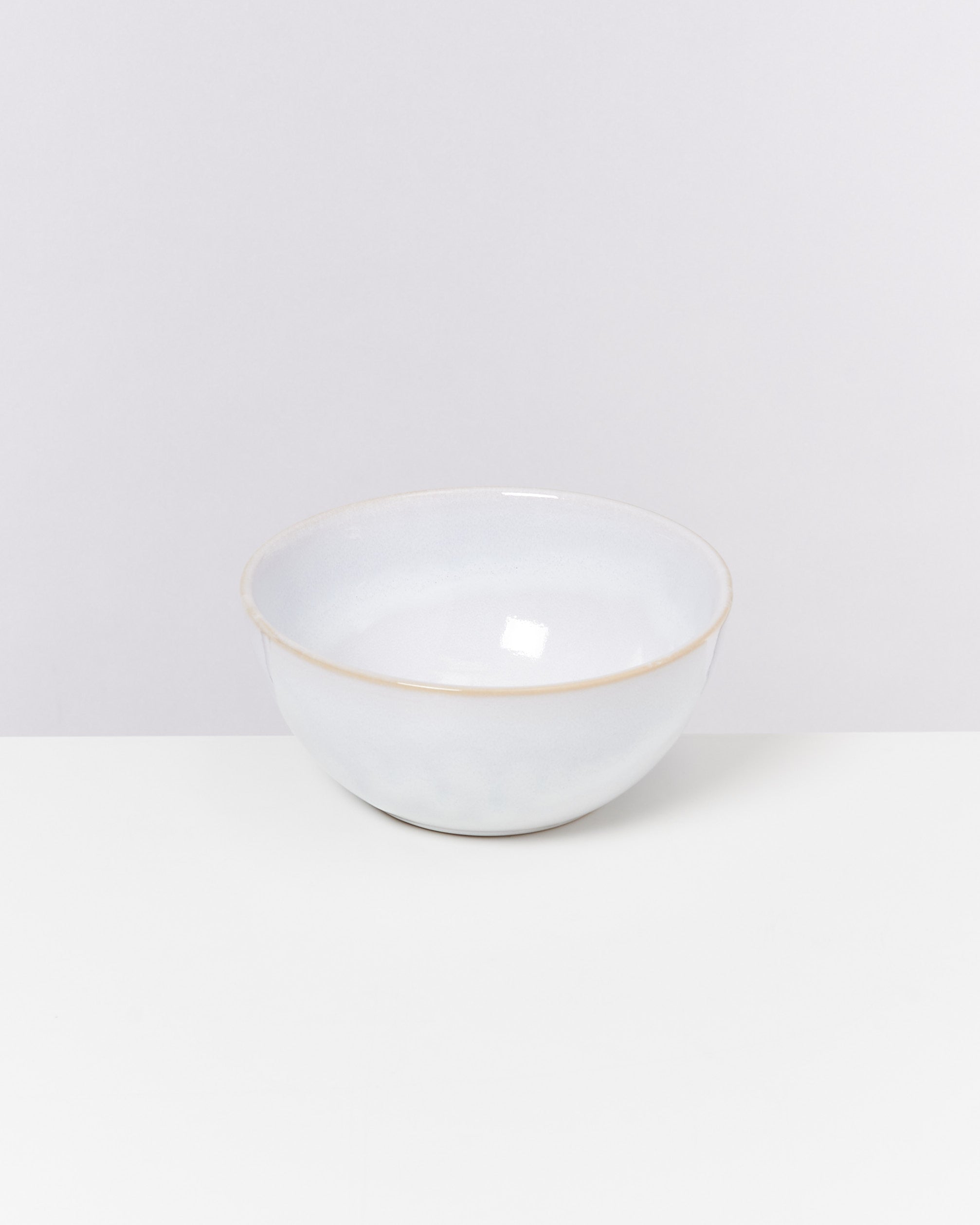 Weiße Keramikschüssel mit glatter Oberfläche auf weißem Hintergrund.