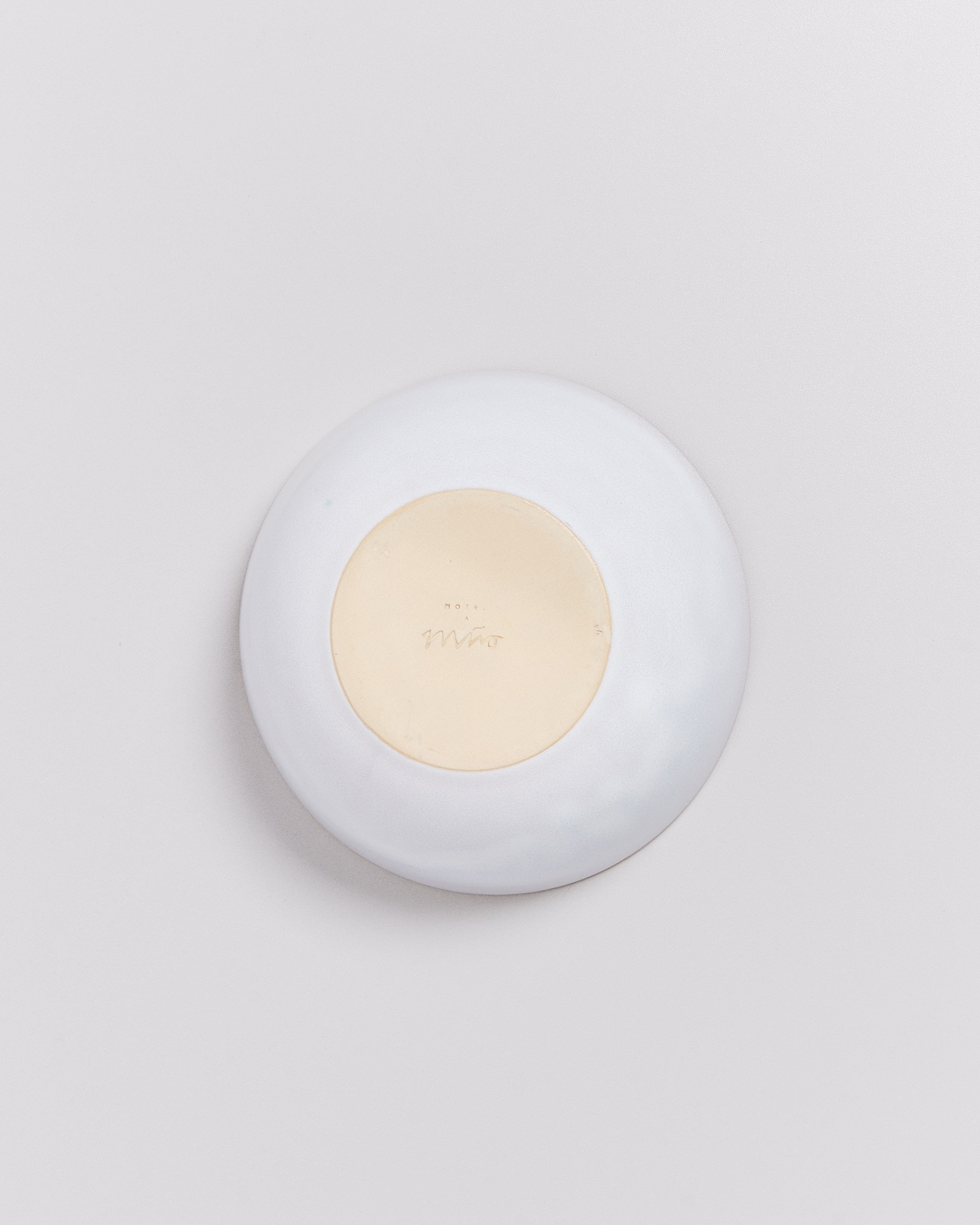 Weiße Schale mit beige Boden, auf dem der Schriftzug "Miro" steht, auf hellem Hintergrund.