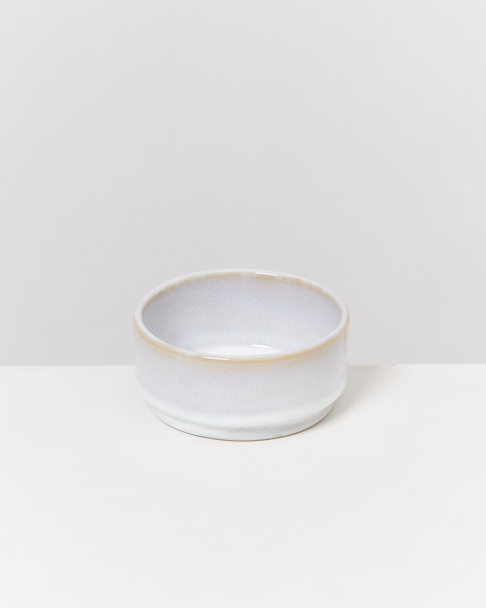 Weiße Keramikschale mit leichtem Glanz auf weißem Hintergrund.