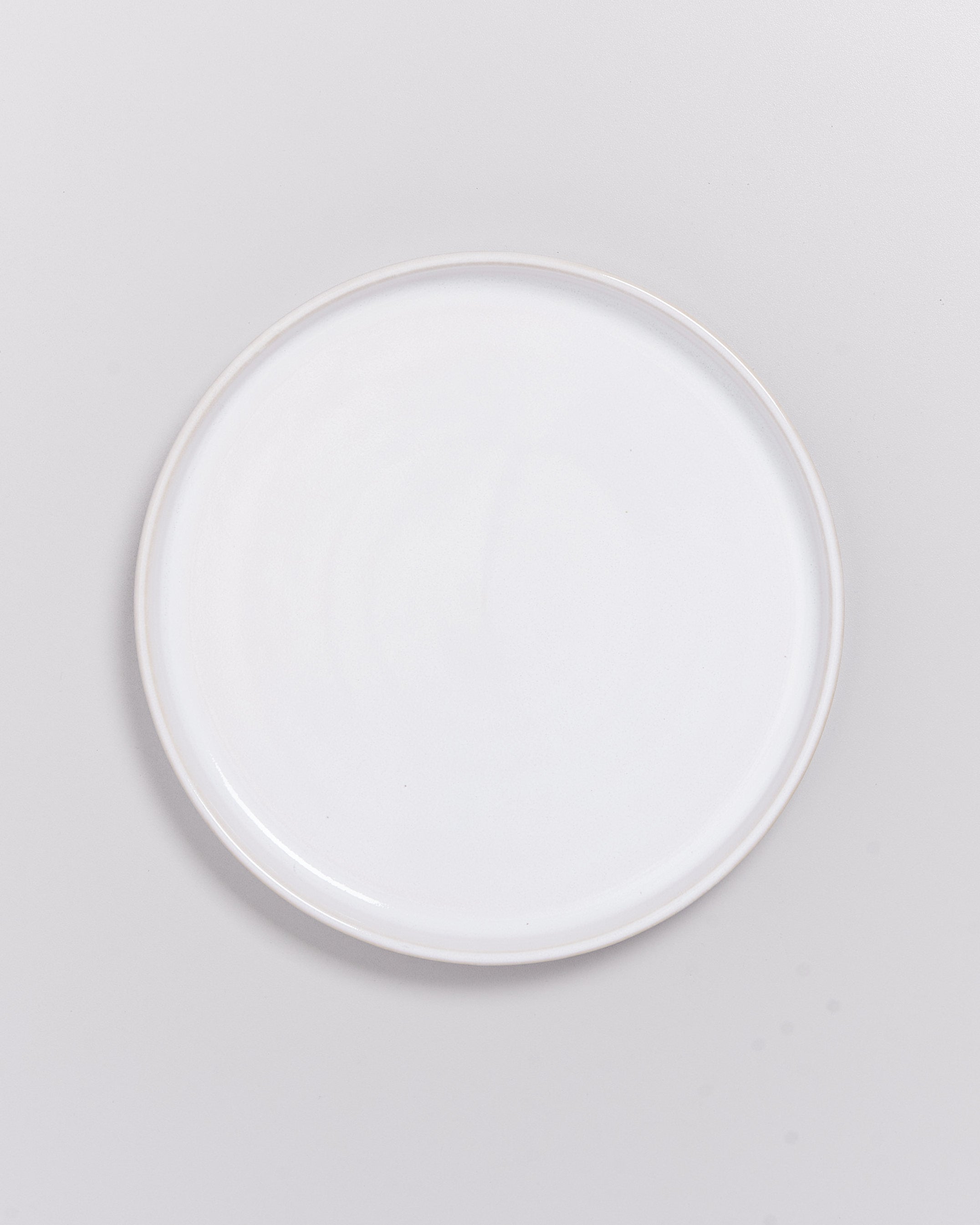 Leer weißer Teller auf einem grauen Hintergrund.