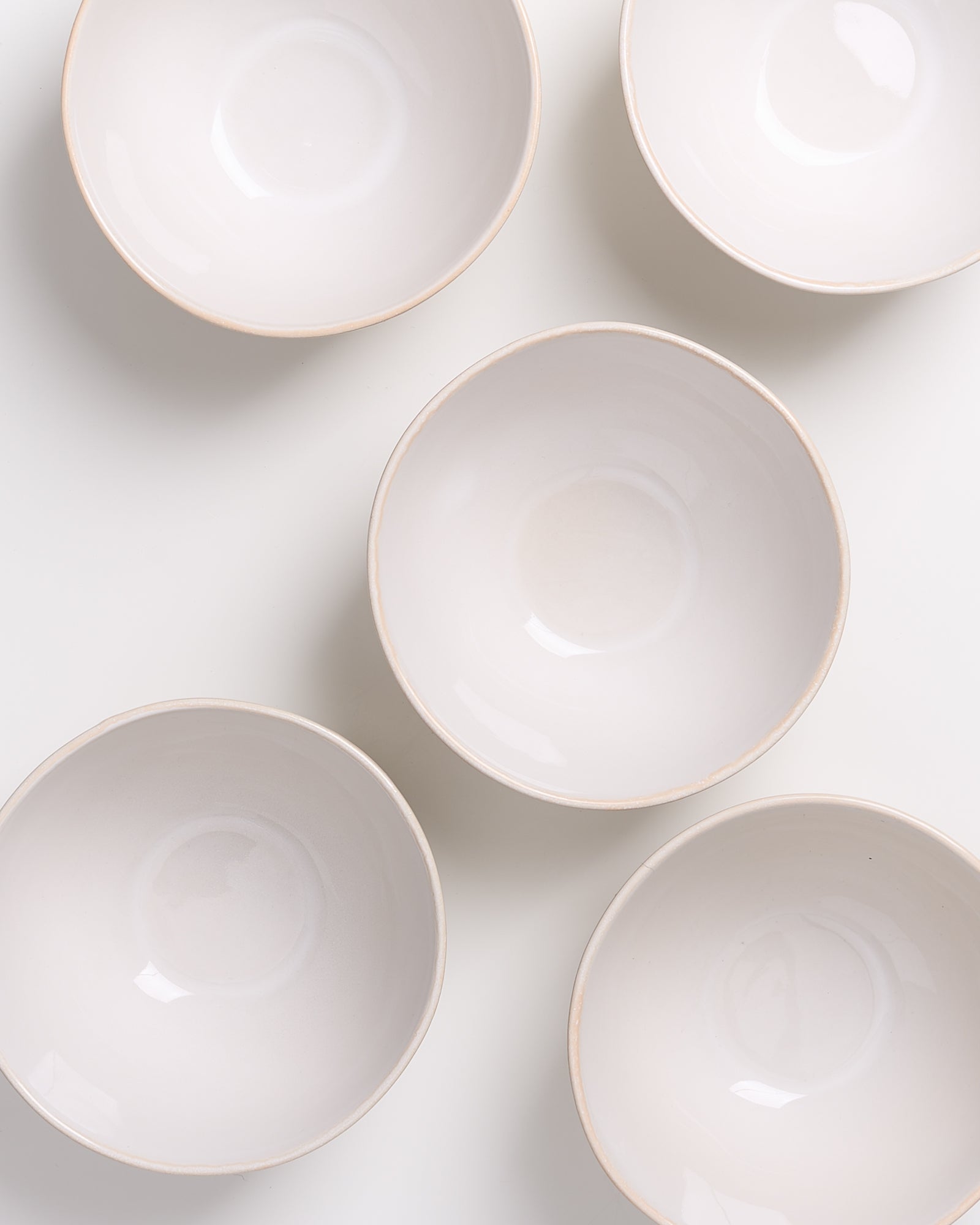 Fünf weiße Schalen sind auf einem weißen Hintergrund angeordnet.