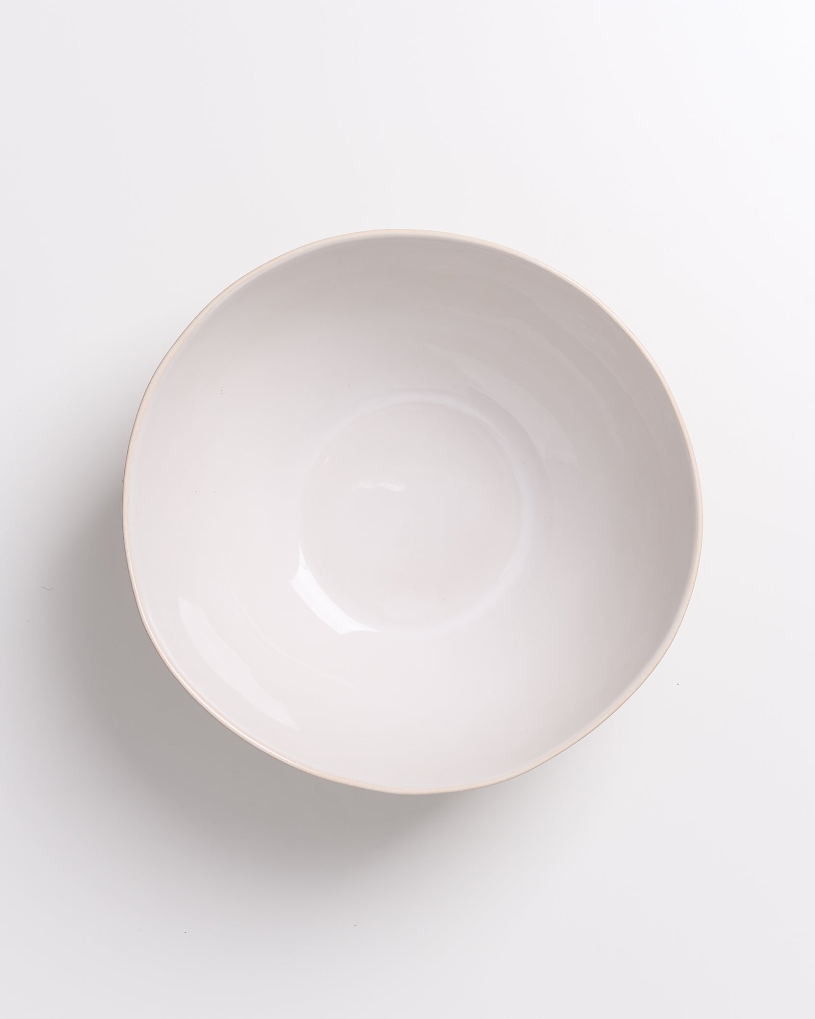 Weiße, leere Keramikschüssel auf weißem Hintergrund.