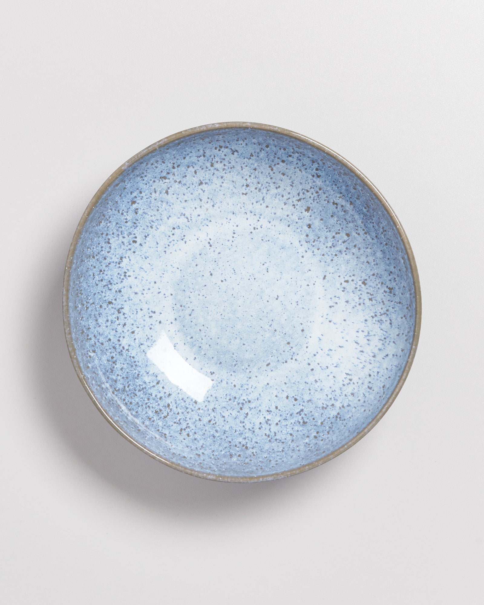 Blaue, gesprenkelte Keramikschüssel auf weißem Hintergrund.