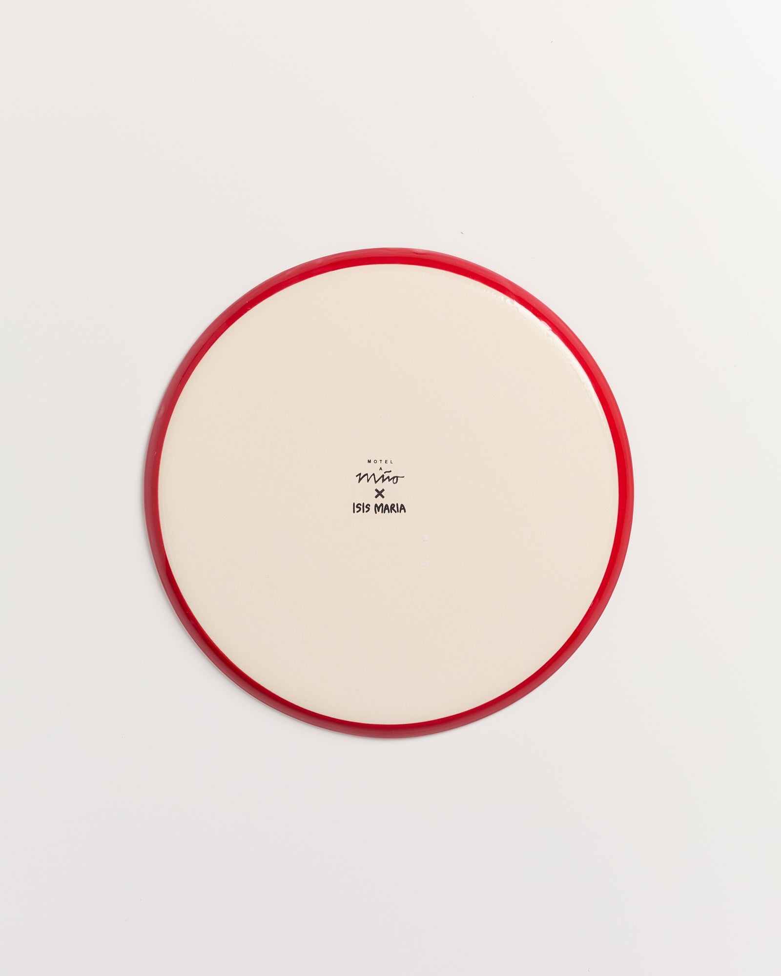 Cremefarbener Teller mit rotem Rand und schwarzem Text in der Mitte auf weißem Hintergrund.