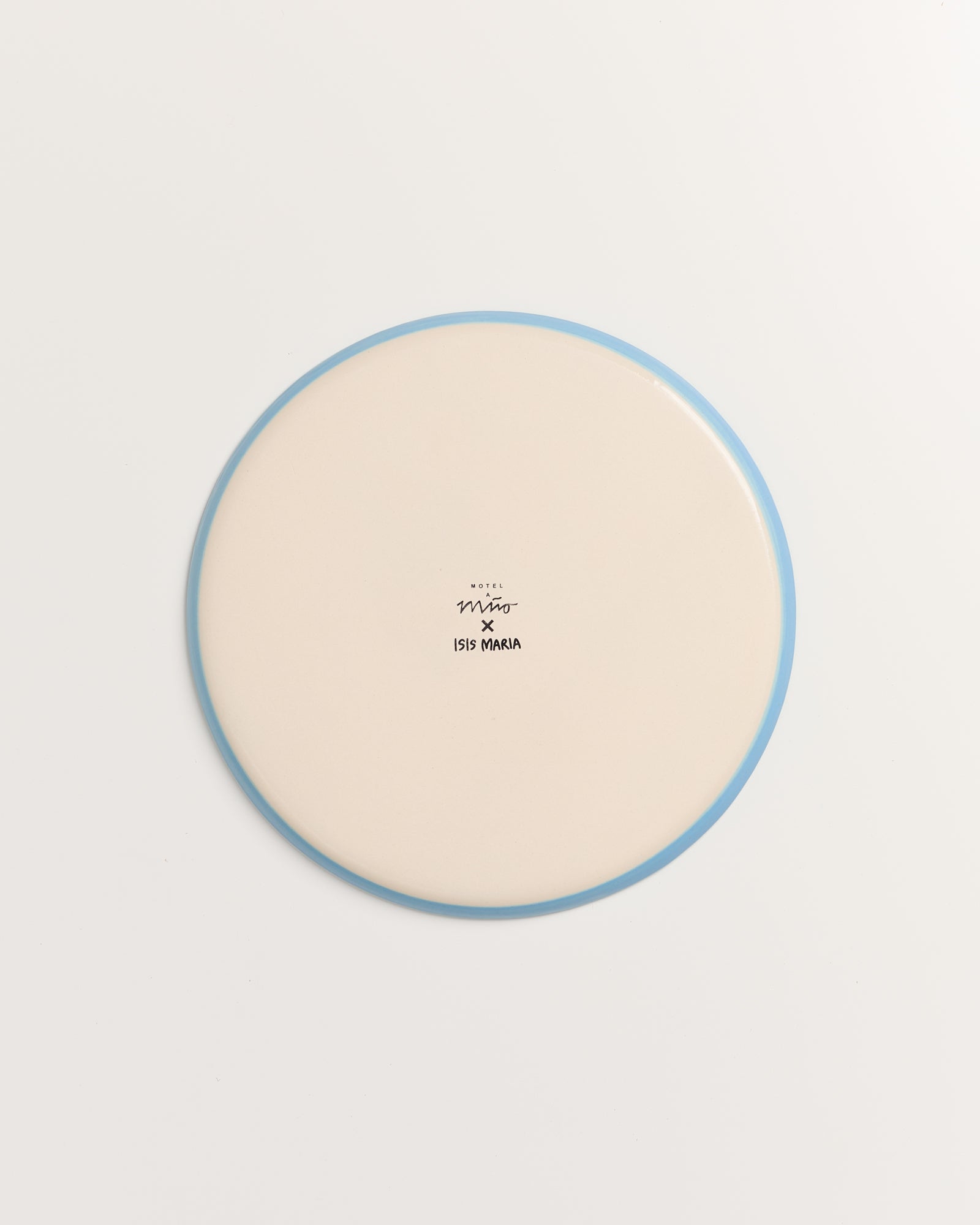 Weiße runde Platte mit einem blauen Rand und einem Logo in der Mitte auf hellem Hintergrund.