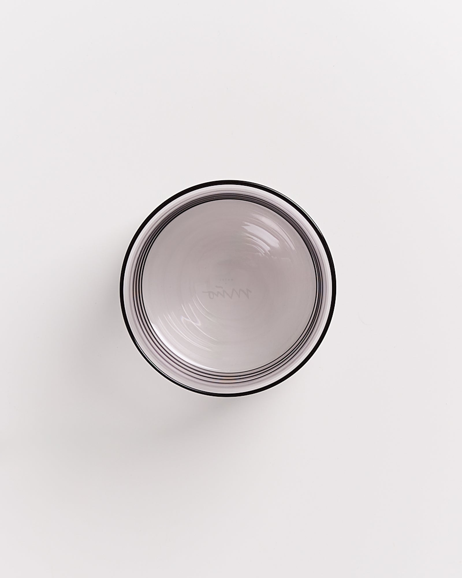 Graue Schüssel mit einem feinen Randmuster auf weißem Hintergrund.