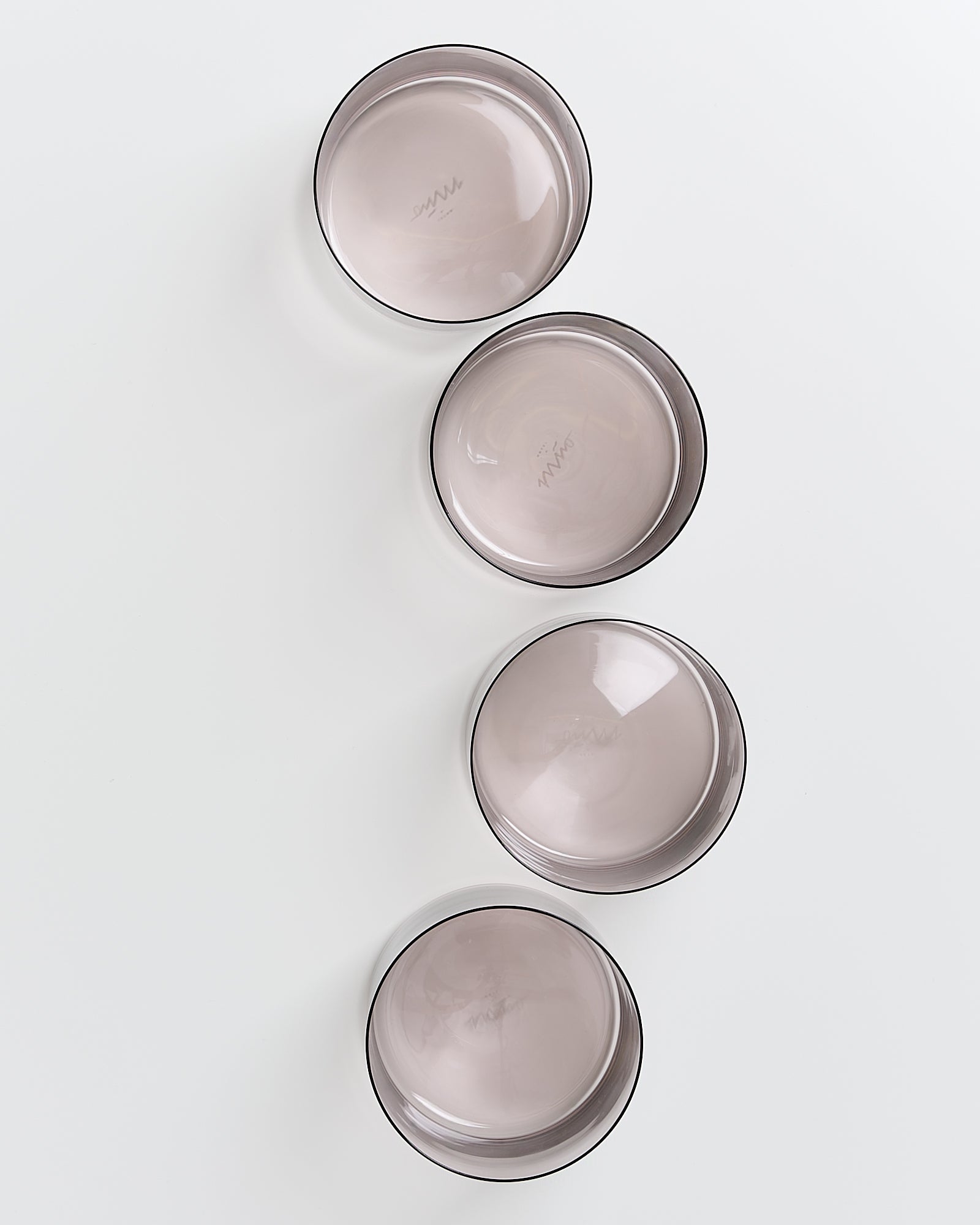 Vier graue, runde Schalen auf weißem Hintergrund in einer diagonalen Linie angeordnet.