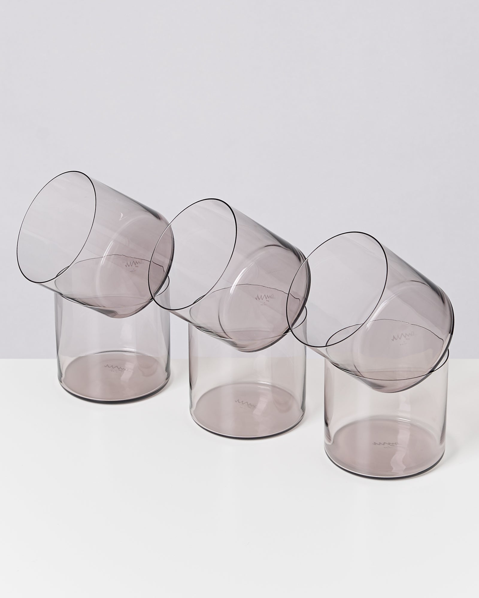 Drei transparente Becher sind schräg nebeneinander aufgestellt und bilden ein geometrisches Muster.