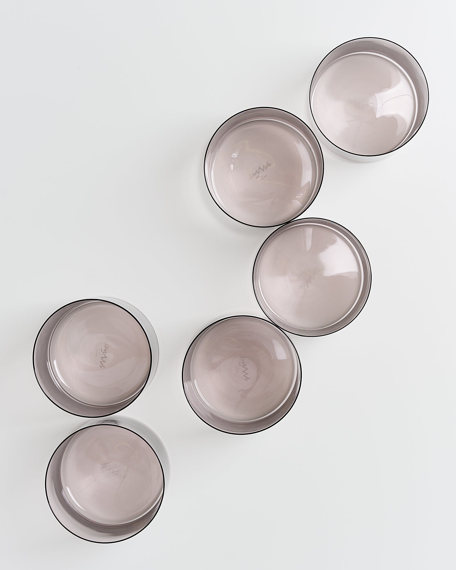 Sechs graue Schalen sind auf einem weißen Hintergrund in einer diagonalen Anordnung platziert.