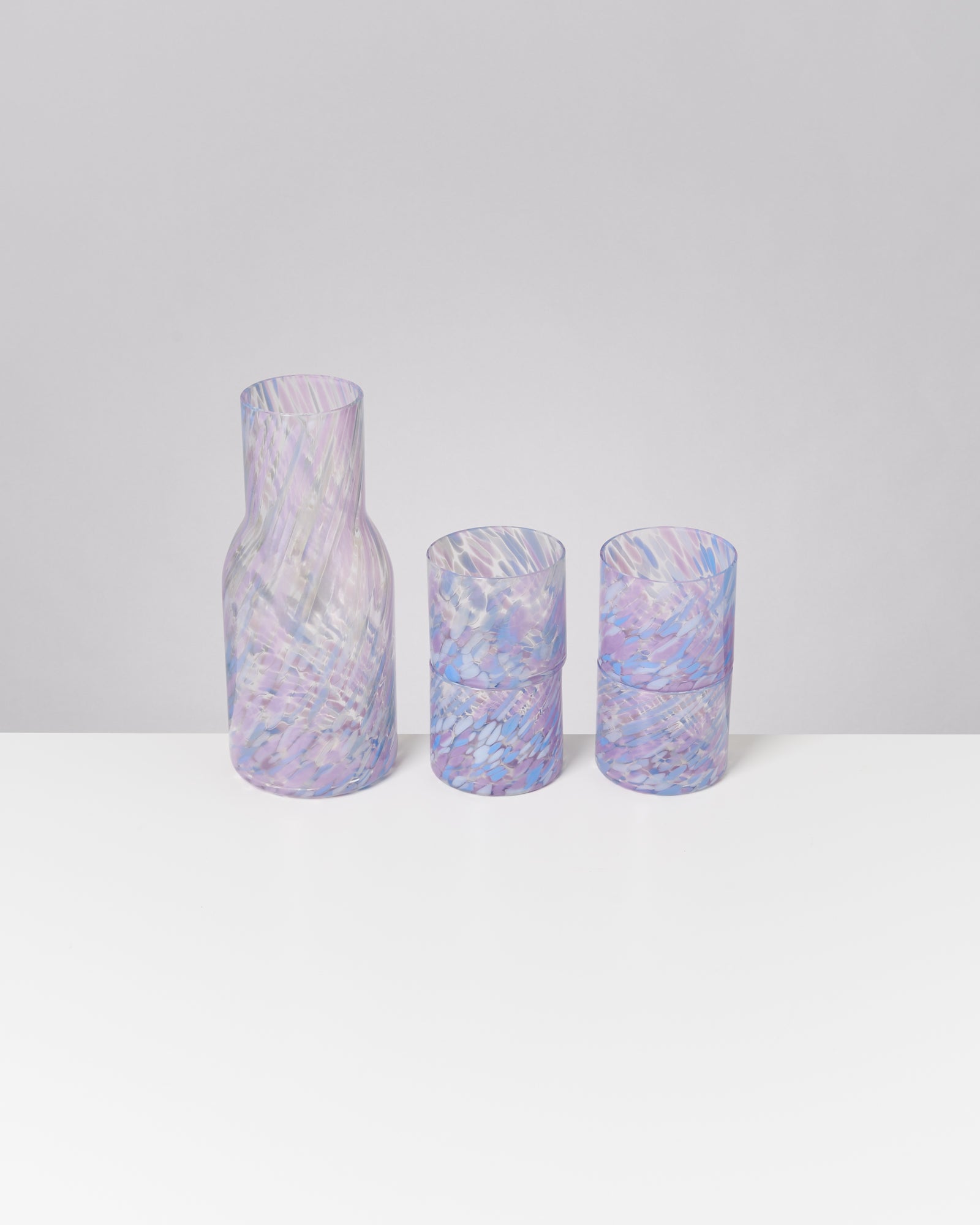 Drei pastellfarbene Gläser mit wirbelnden Mustern auf einem weißen Hintergrund.