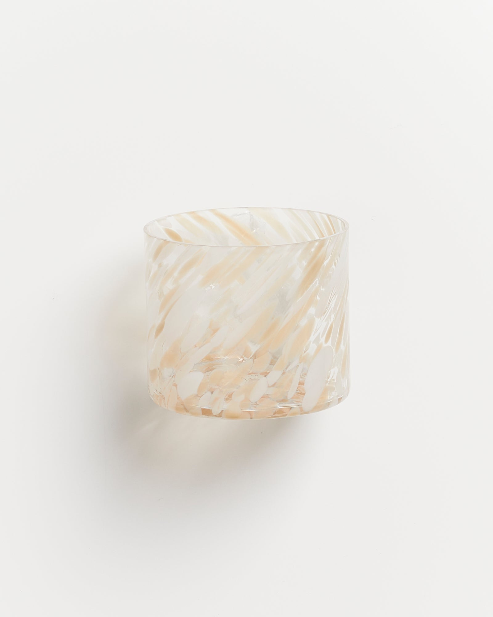 Gläsernes Gefäß mit weiß-beigen abstrakten Mustern vor weißem Hintergrund.