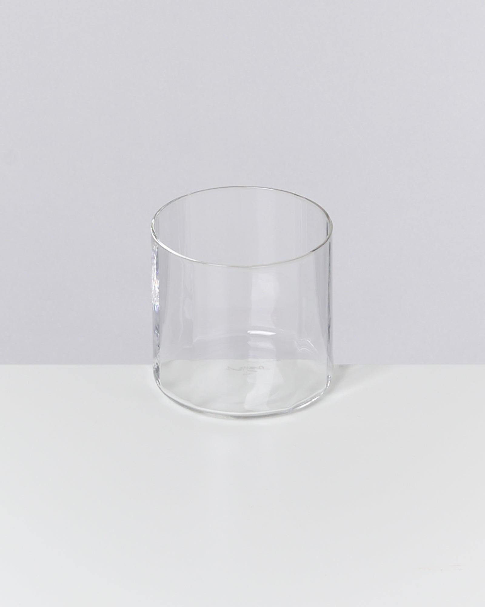 Klare zylindrische Glasvase auf weißem Hintergrund.