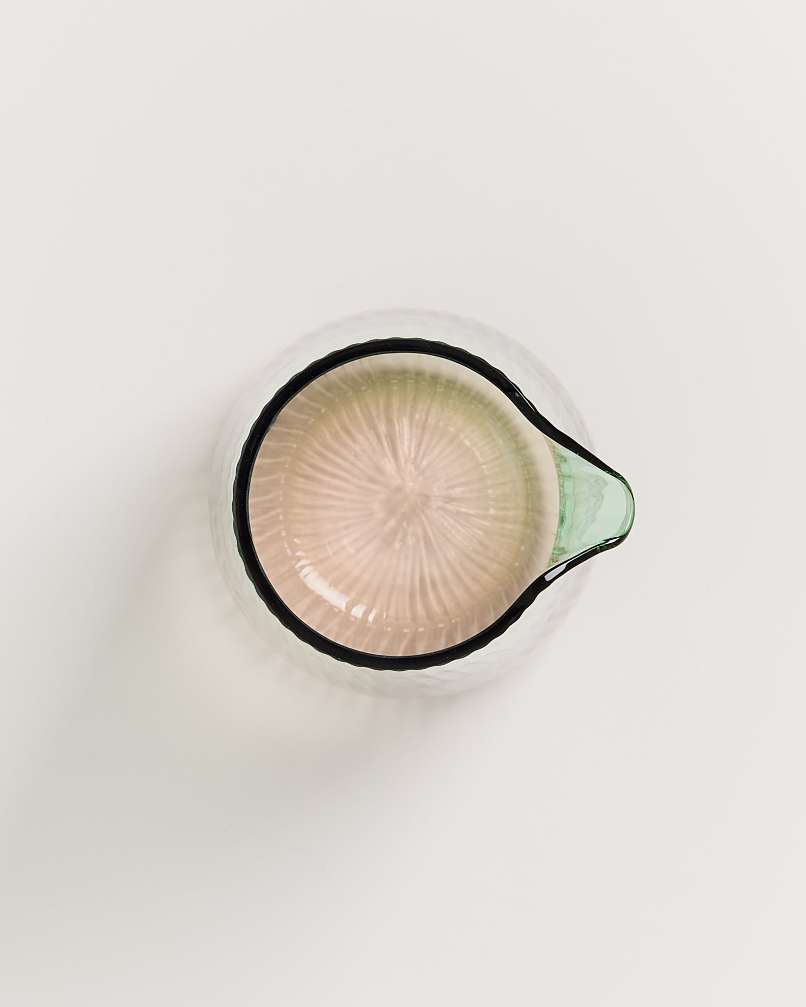 Glasbehälter mit Ausguss, von oben gesehen, auf weißem Hintergrund.