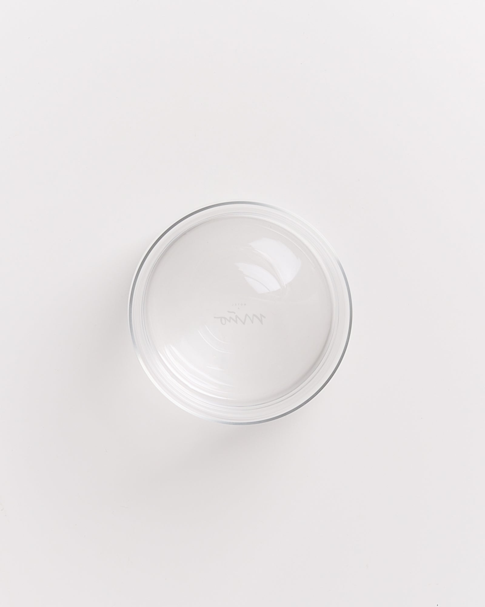 Klare Glasschüssel auf weißem Hintergrund von oben betrachtet.