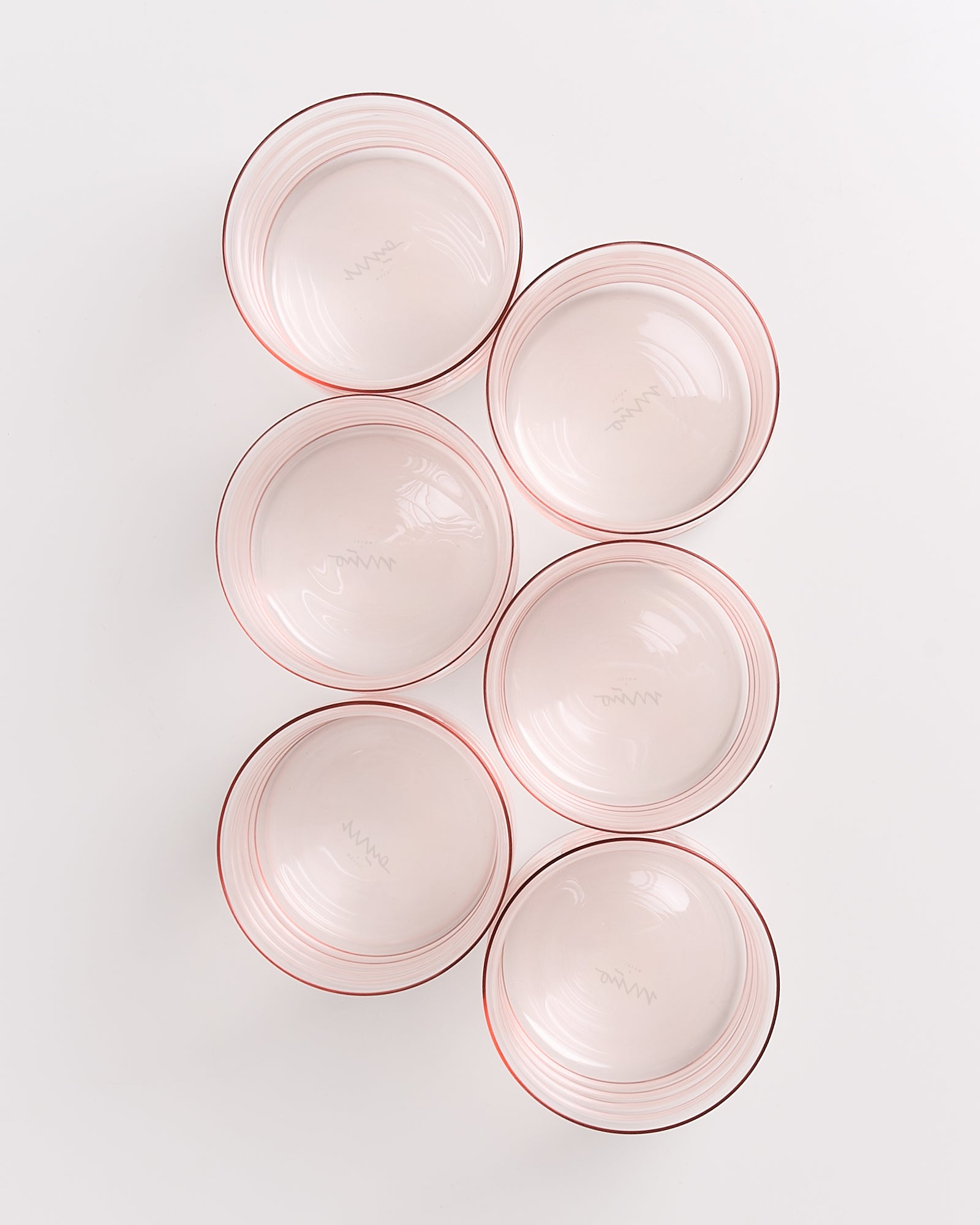 Sechs leere, durchsichtige Schalen mit rotem Rand auf weißem Hintergrund in symmetrischer Anordnung.