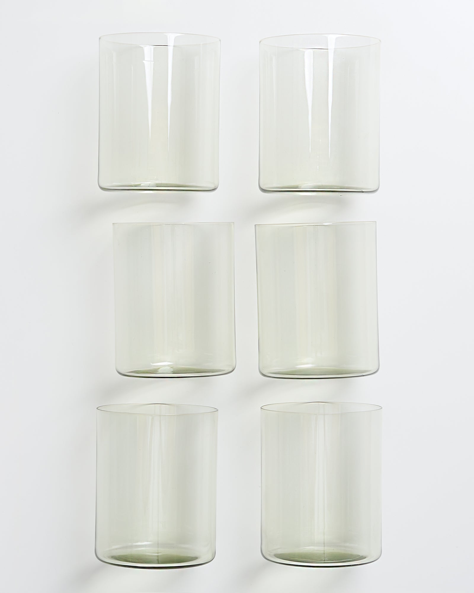 Sechs durchsichtige Trinkgläser in zwei Reihen à drei Gläser auf weißem Hintergrund.