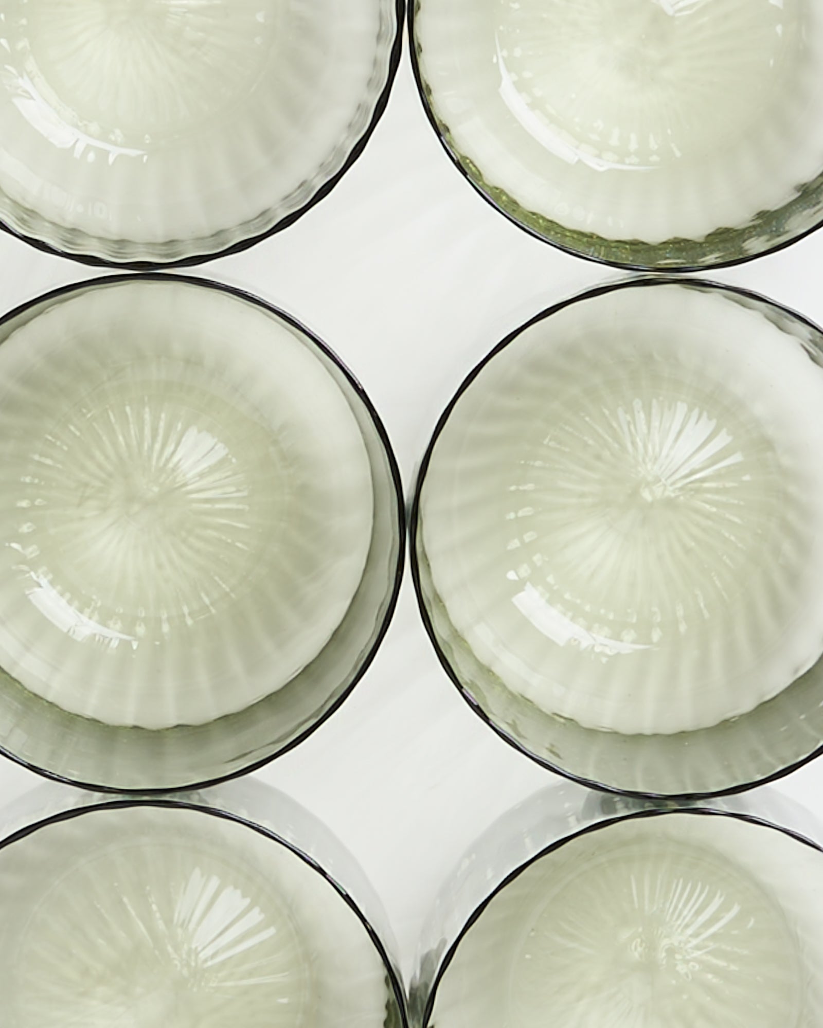 Sechs transparente, runde Schalen mit geriffelter Struktur sind auf weißem Hintergrund angeordnet.