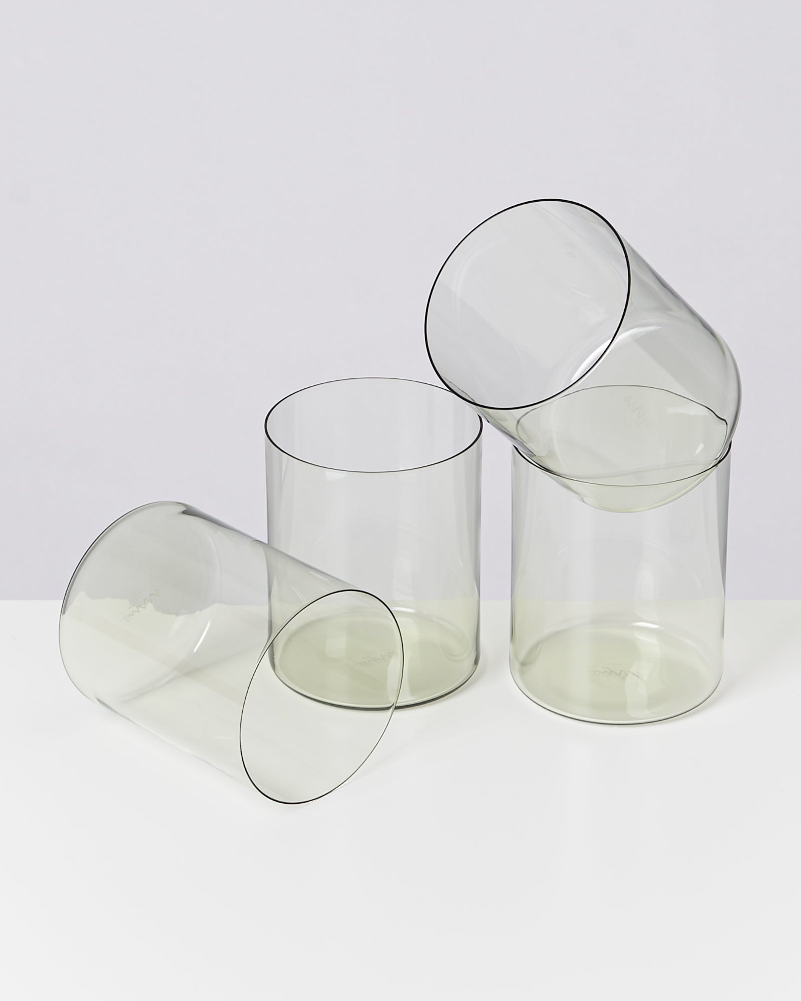 Vier transparente, aufeinander gestapelte Gläser auf einem weißen Untergrund.