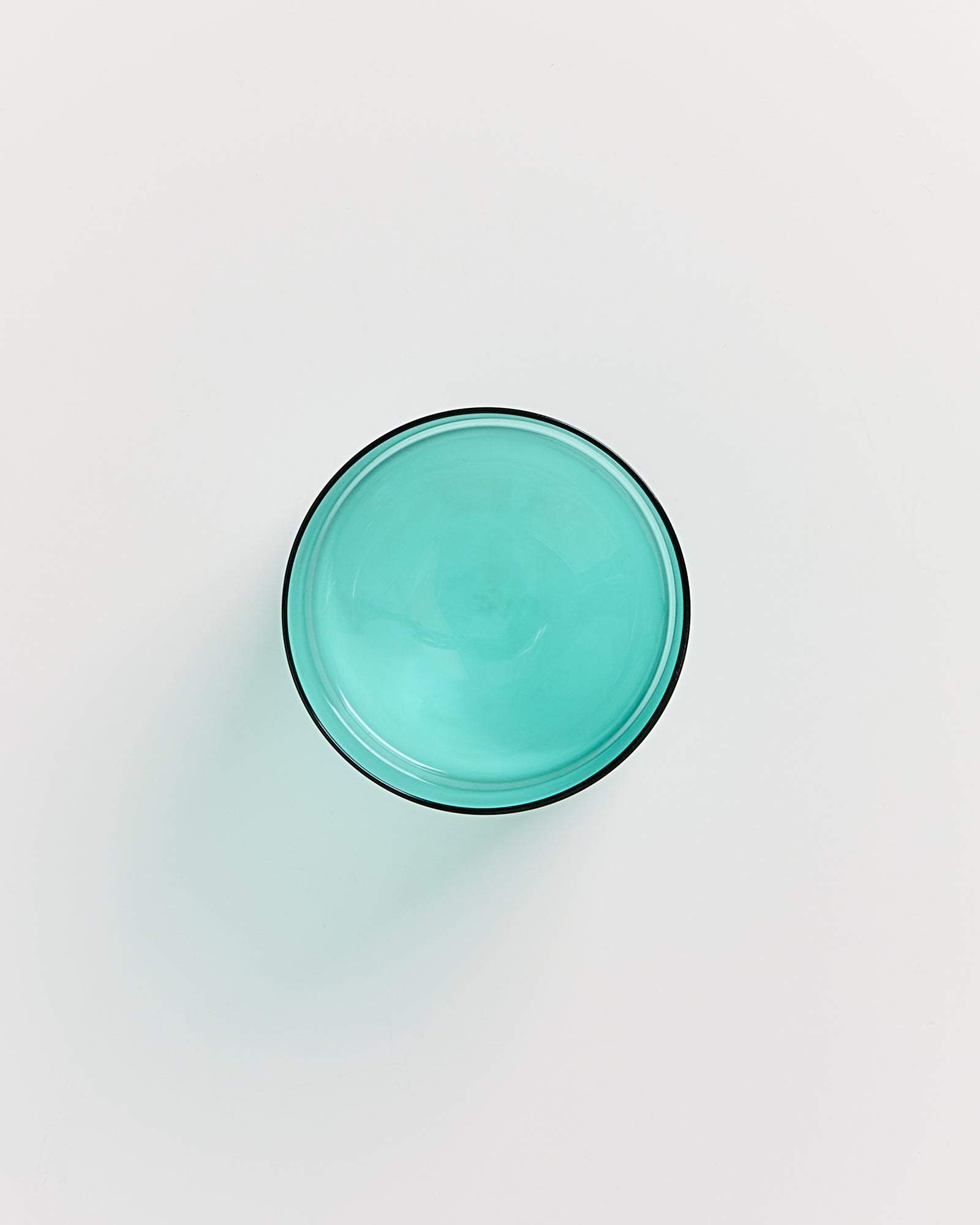 Obenansicht einer türkisfarbenen Schüssel auf weißem Hintergrund.