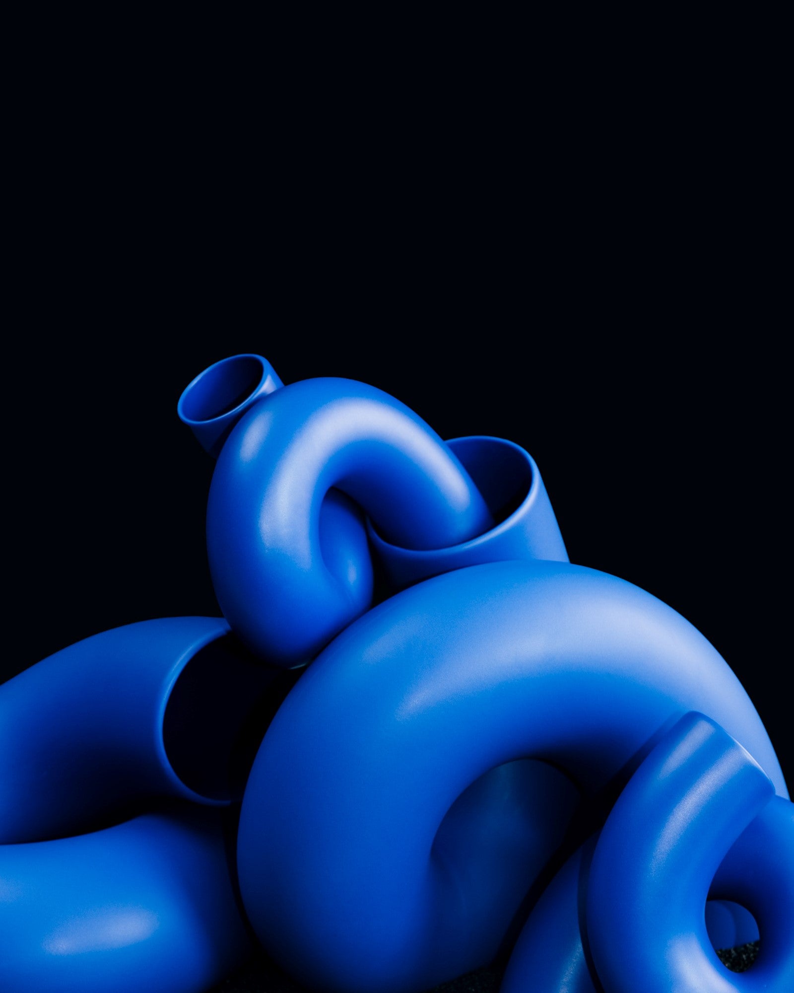 Kunstwerk aus ineinander verschlungenen, blauen Röhren vor einem schwarzen Hintergrund.