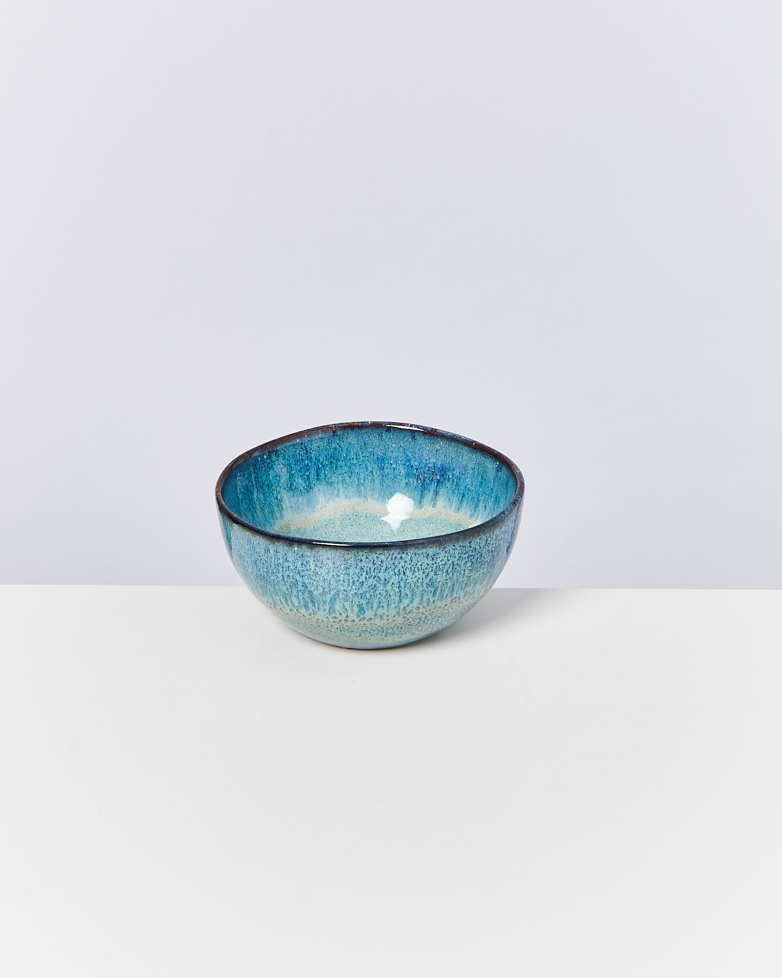 Blaue Keramikschale mit Farbverlauf auf weißem Hintergrund.