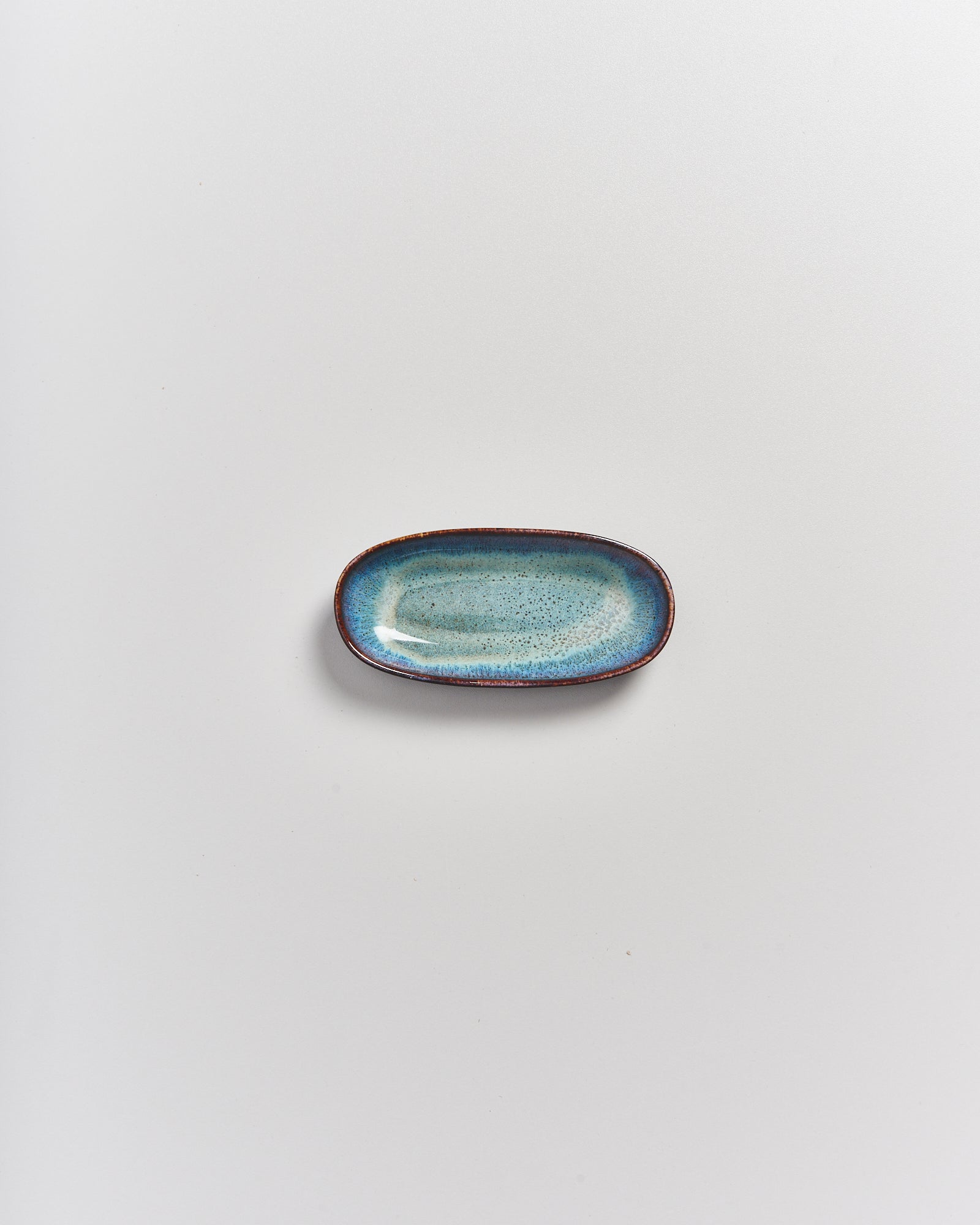 Ovaler Keramikteller in Blau auf weißem Hintergrund.