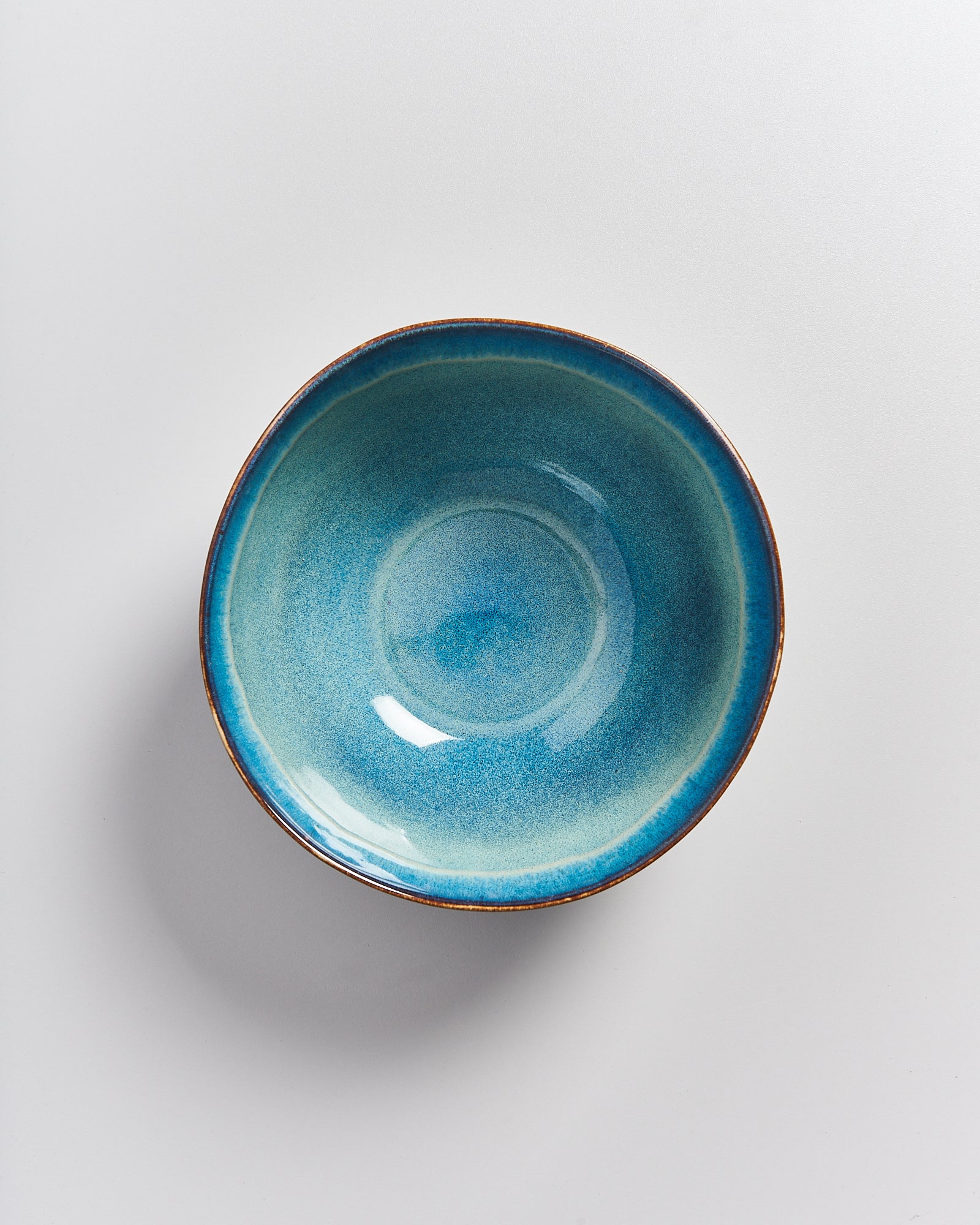 Keramikschüssel in einem blauen Farbverlauf auf einer grauen Oberfläche.