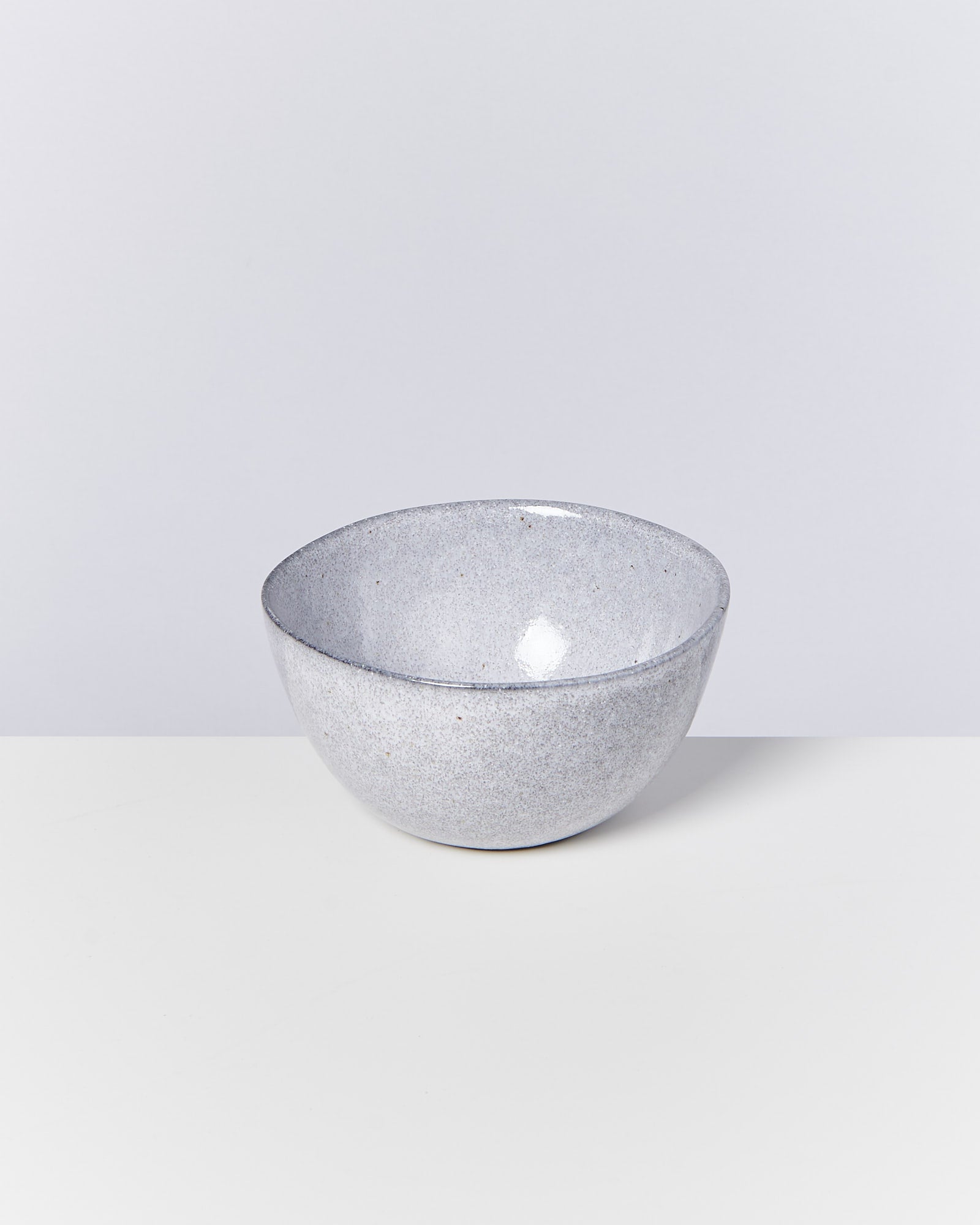 Graue, runde Schale aus Keramik auf hellem Hintergrund.