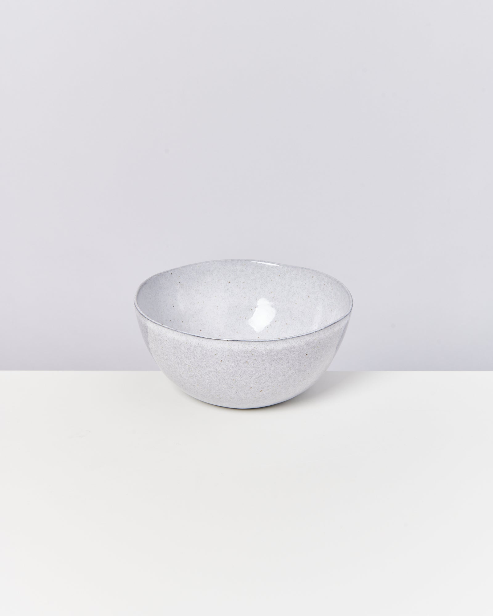 Graue, glänzende Schüssel auf weißem Hintergrund.